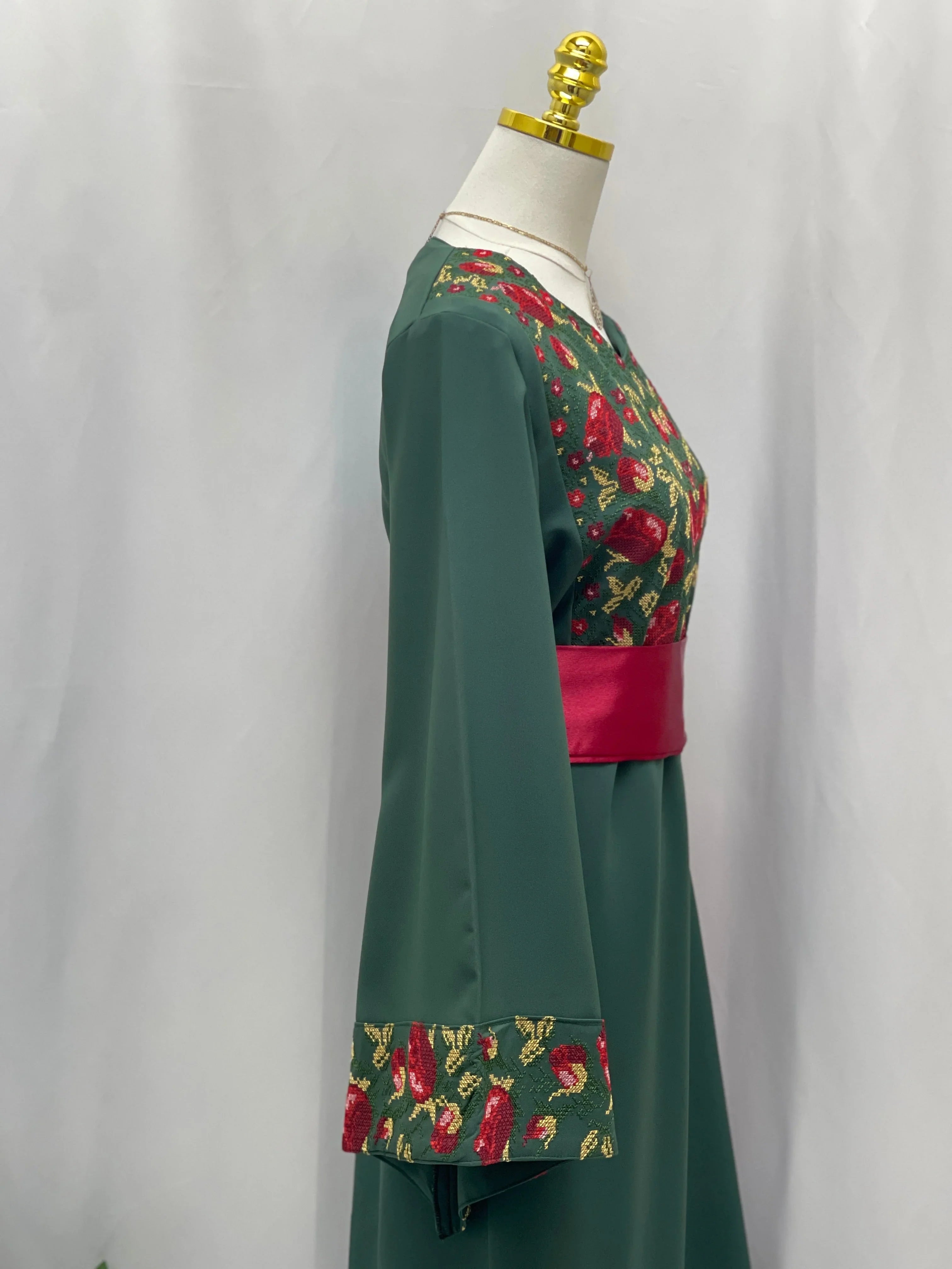 Palestinian Elegance Emerald Blossom EmbroideredThobe green dress thobe with red floral embroidery on bodice cuffs and pink sash