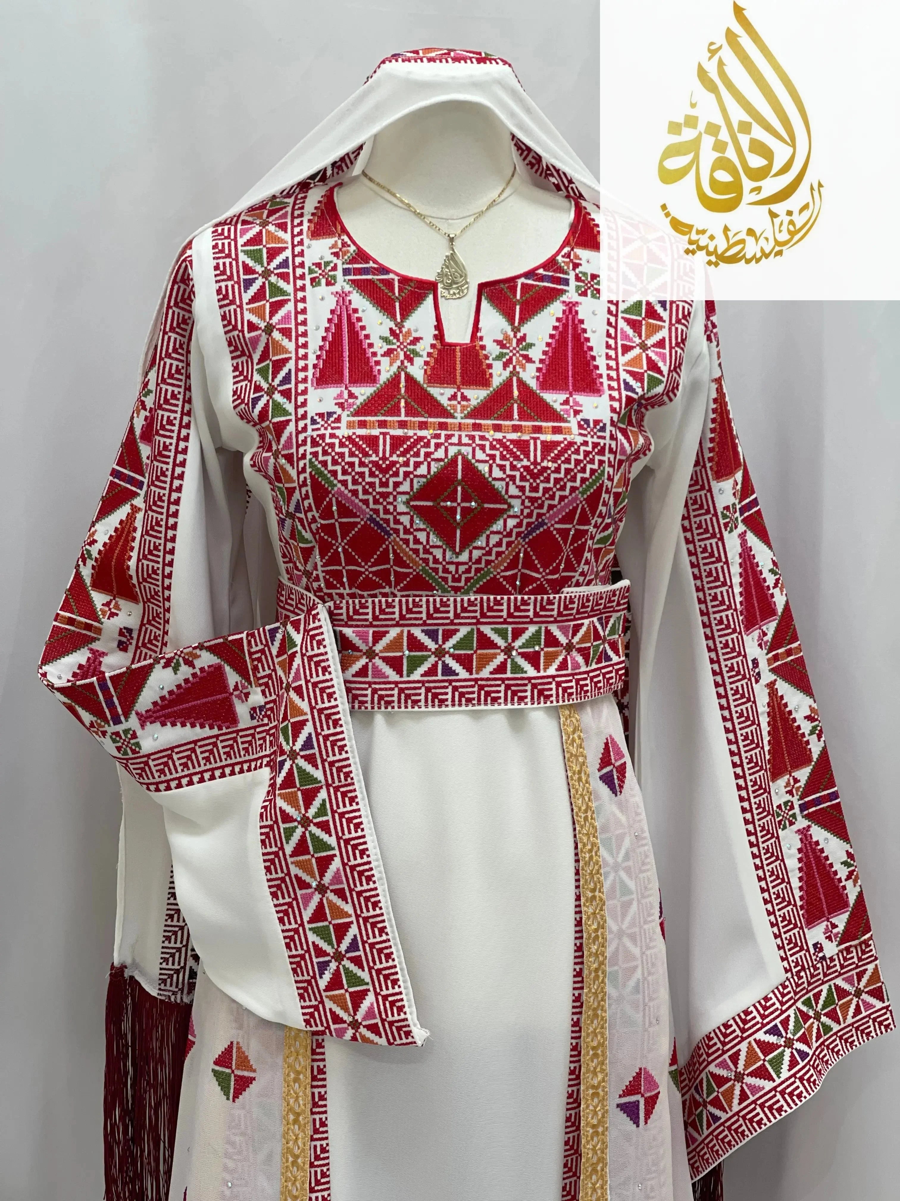 Embroidered Falahi thoub with overskirt in white and red geometric patterns by Palestinian Elegance