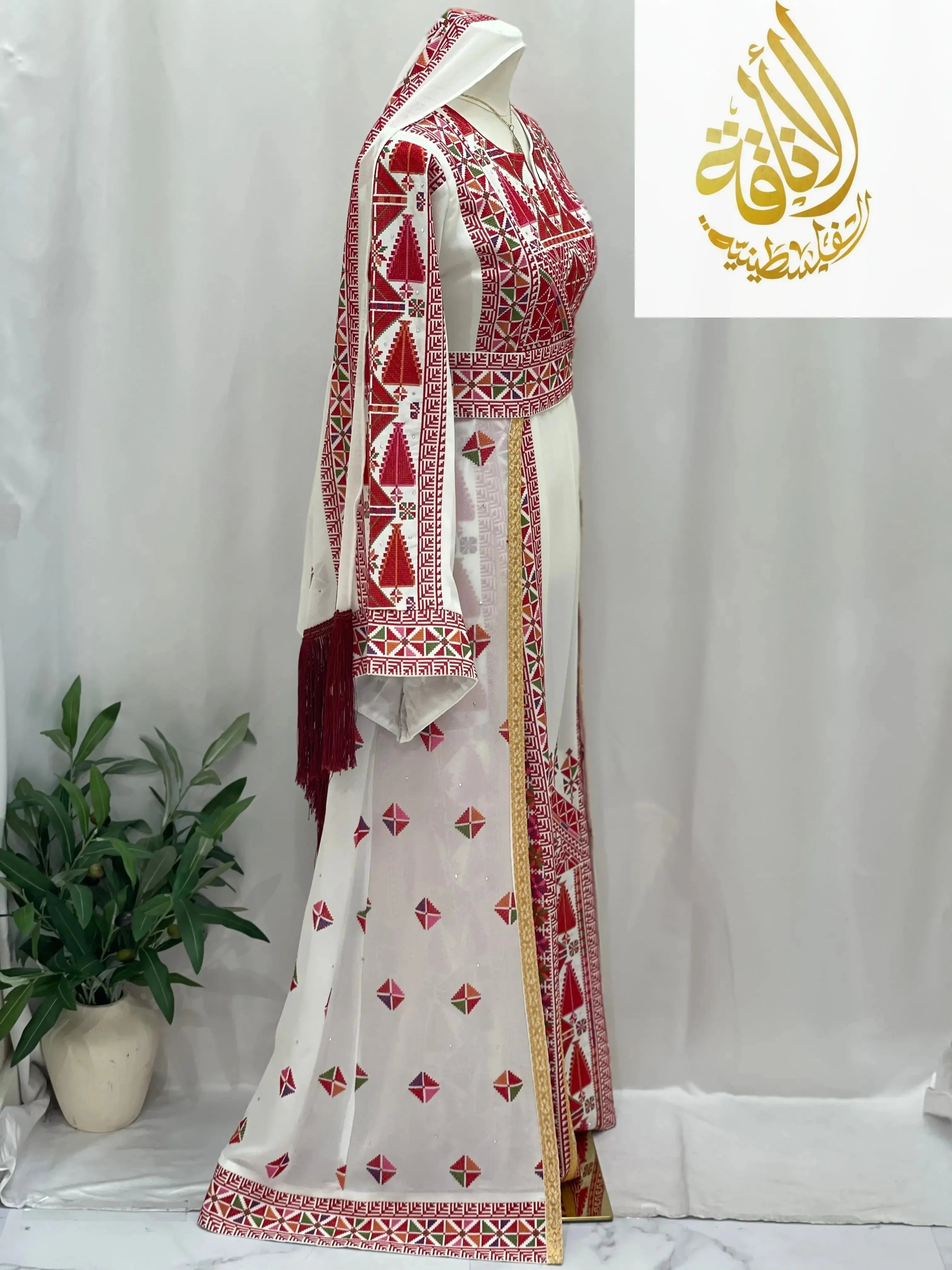 Embroidered Falahi thoub with overskirt by Palestinian Elegance in white with red and gold traditional patterns