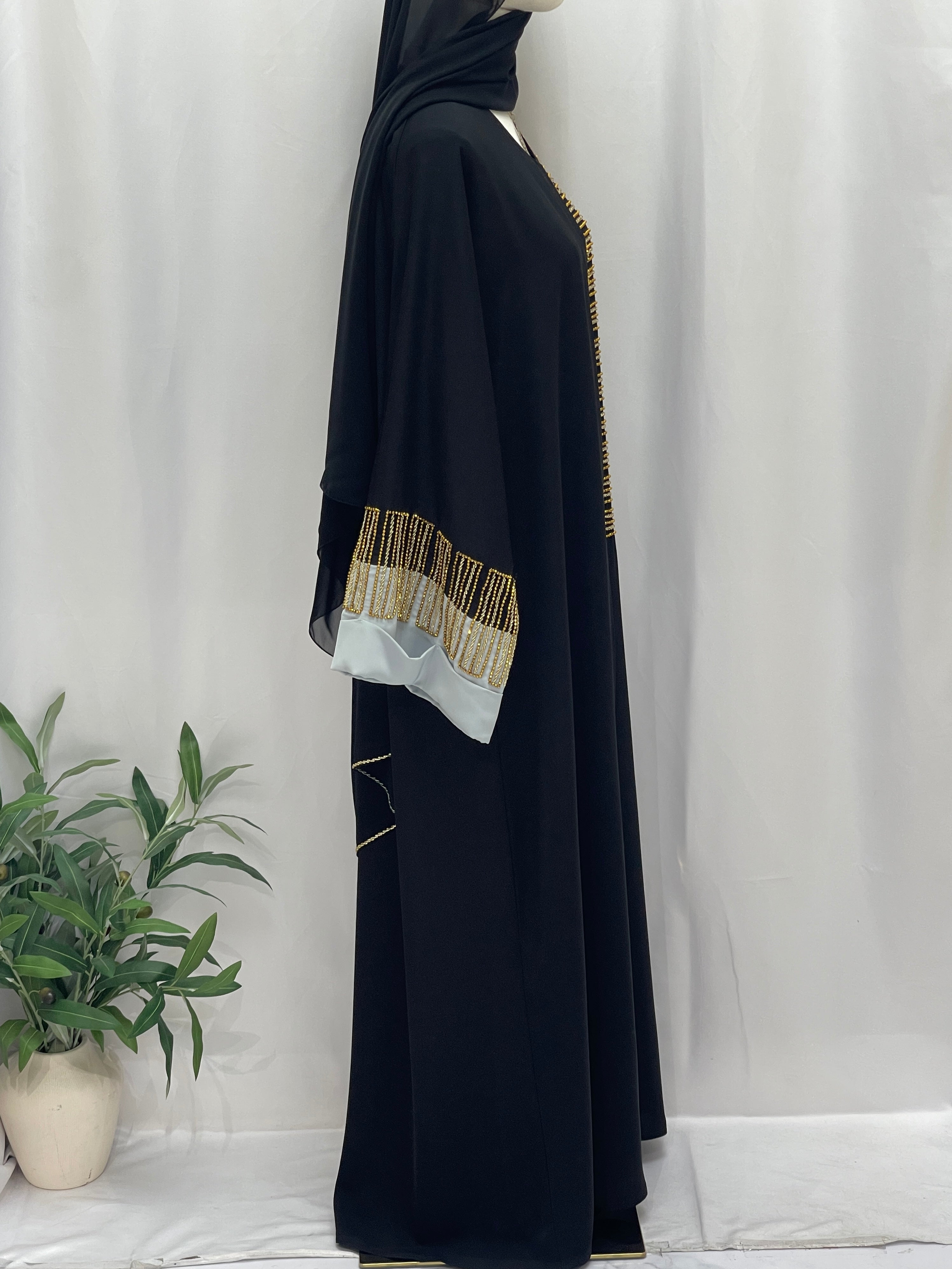 Palestinian Elegance black abaya side view with gold bead trim and white cuff detail Fancy Beads Dubai Abaya