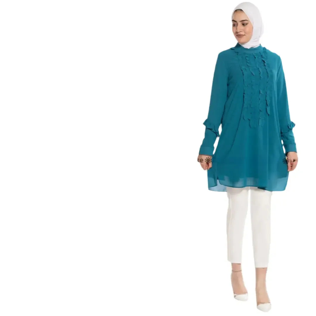 Palestinian Elegance luxury women's embroidered shirt in teal with ruffle details, styled with white pants and heels