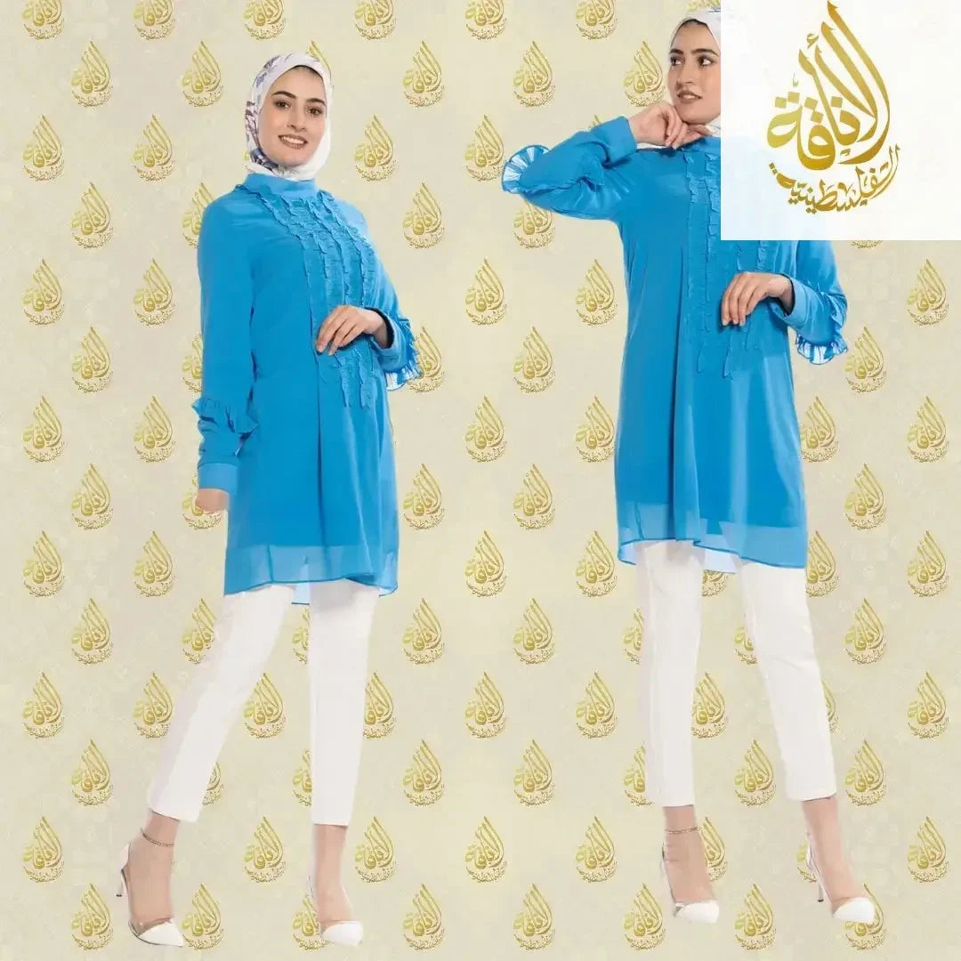 Luxury women's embroidered shirt by Palestinian Elegance in bright blue casual style worn with white pants