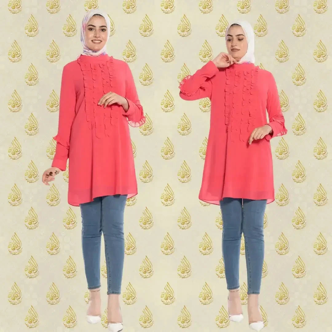 Luxury women's embroidered shirt in coral pink worn with jeans and white heels by Palestinian Elegance