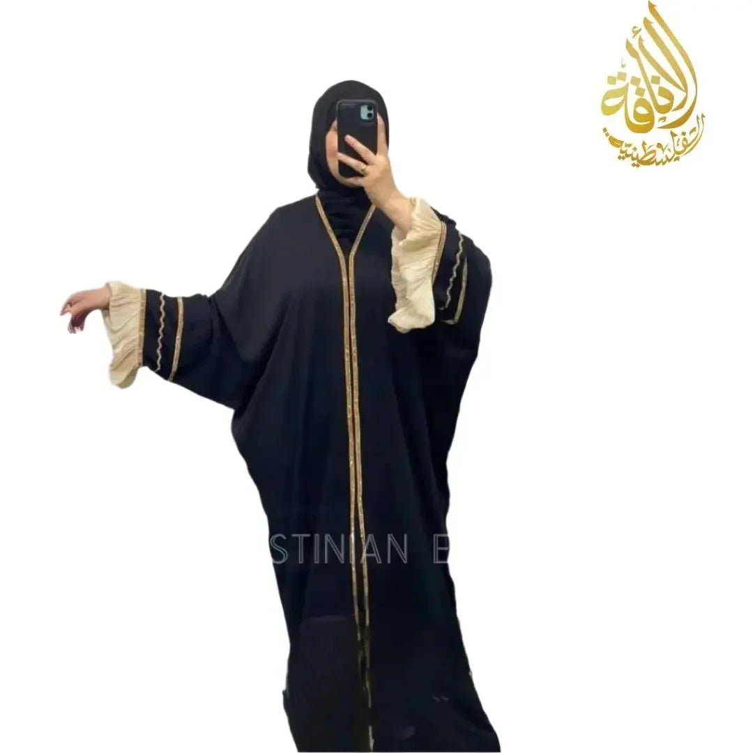 Palestinian Elegance free size black abaya with gold trim and cream ruffle sleeves worn by woman