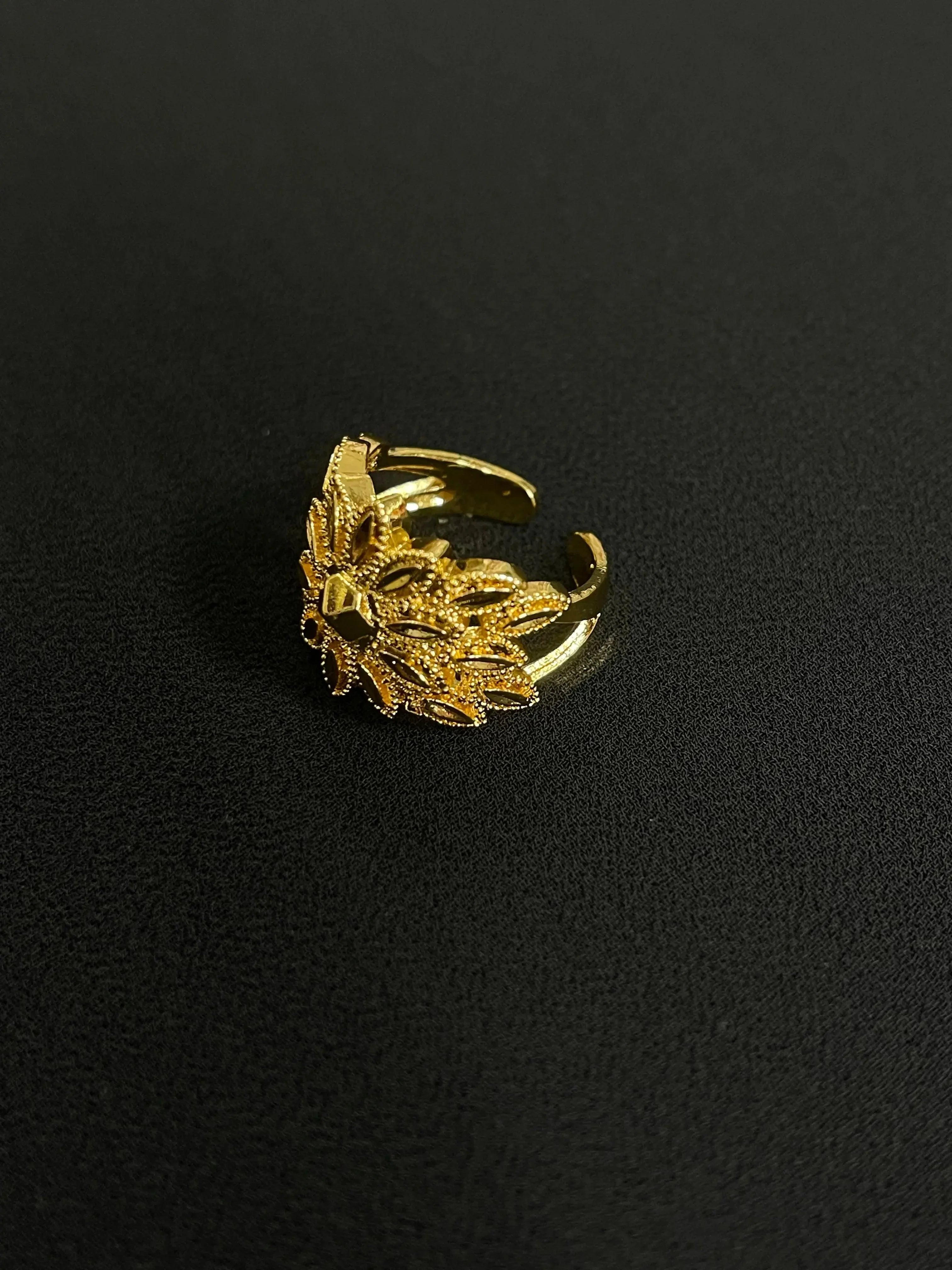 Palestinian gold jewelry set detailed gold ring with intricate leaf design on black background