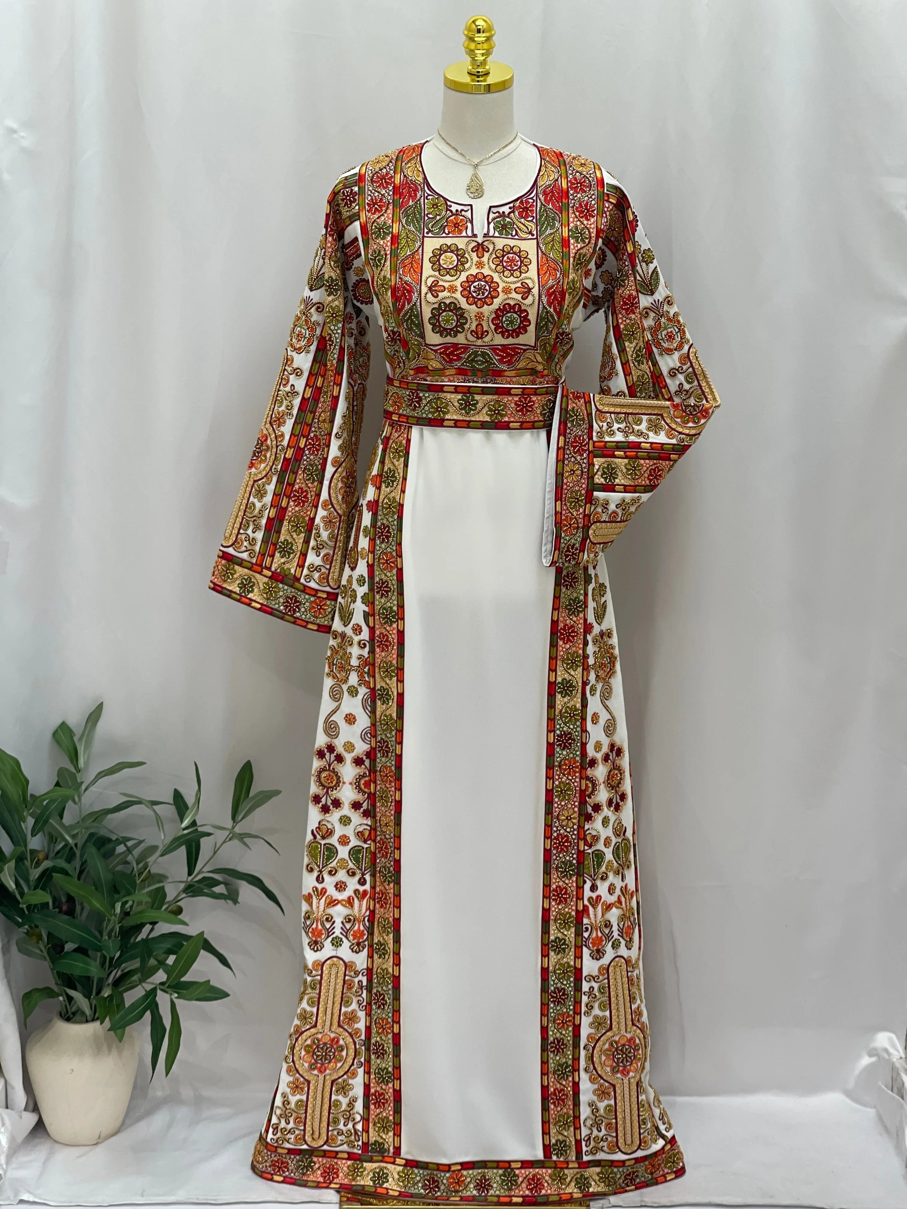 Golden Blossom Beaded Embroidered Thobe on mannequin white dress with red green and gold Palestinian floral embroidery and sash