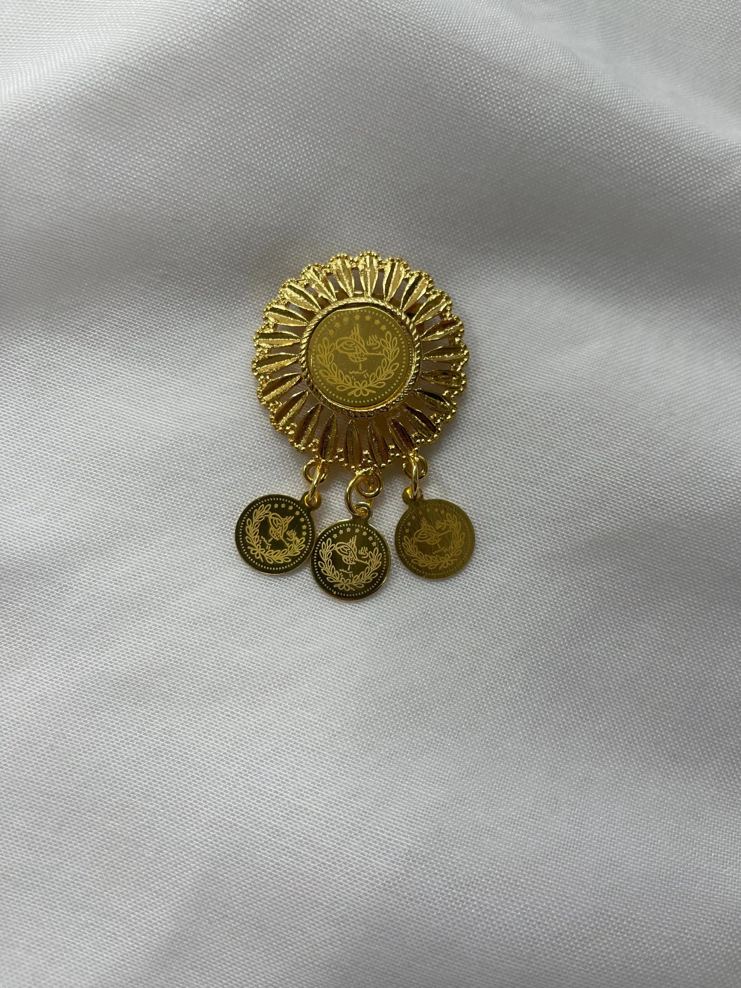 Palestinian Elegance imitation gold lapel pin with intricate circular design and three dangling coins