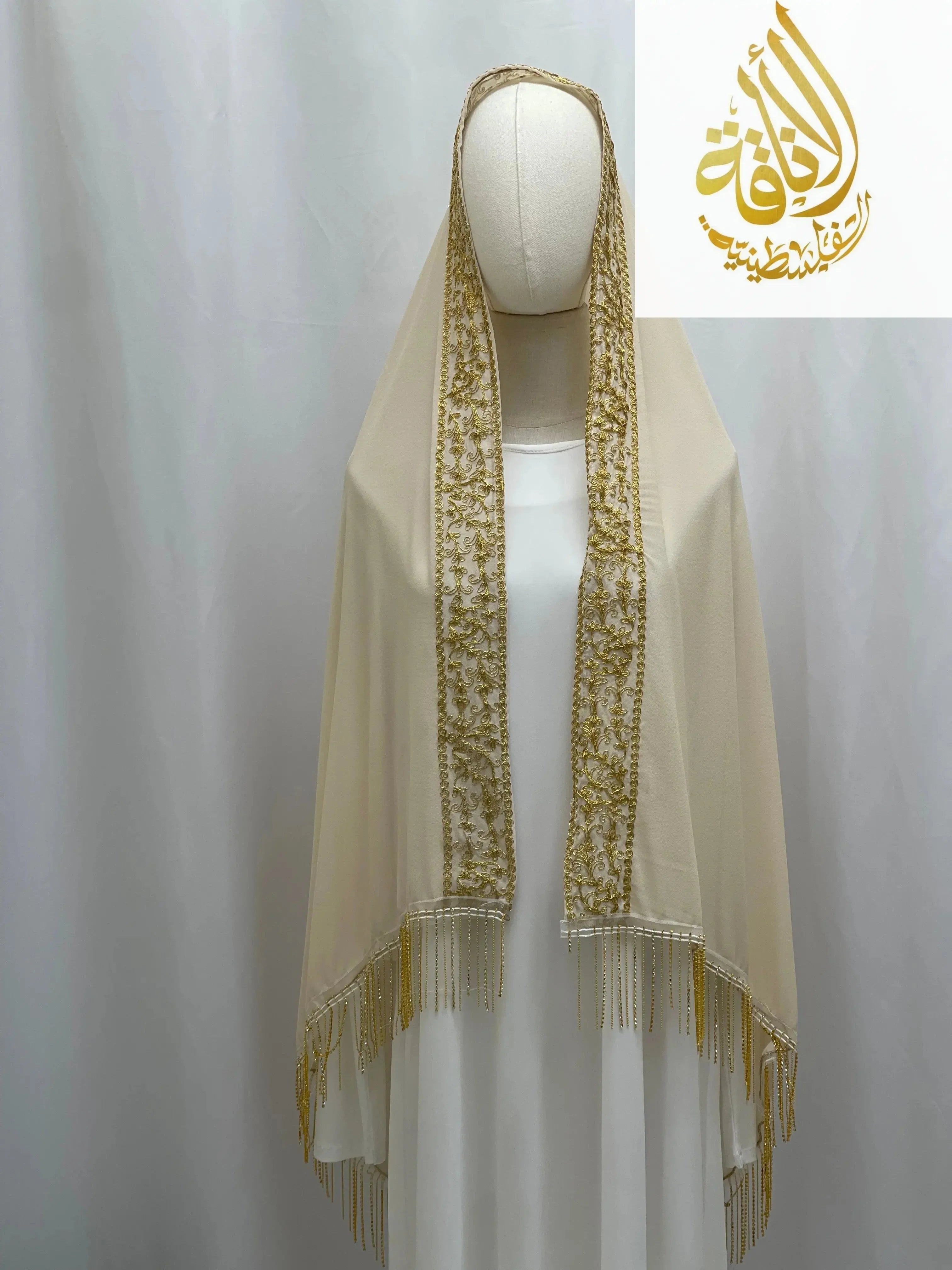Cream-colored Palestinian Traditional Modest Fashion Kasab Khirka with intricate gold embroidery and fringe detailing