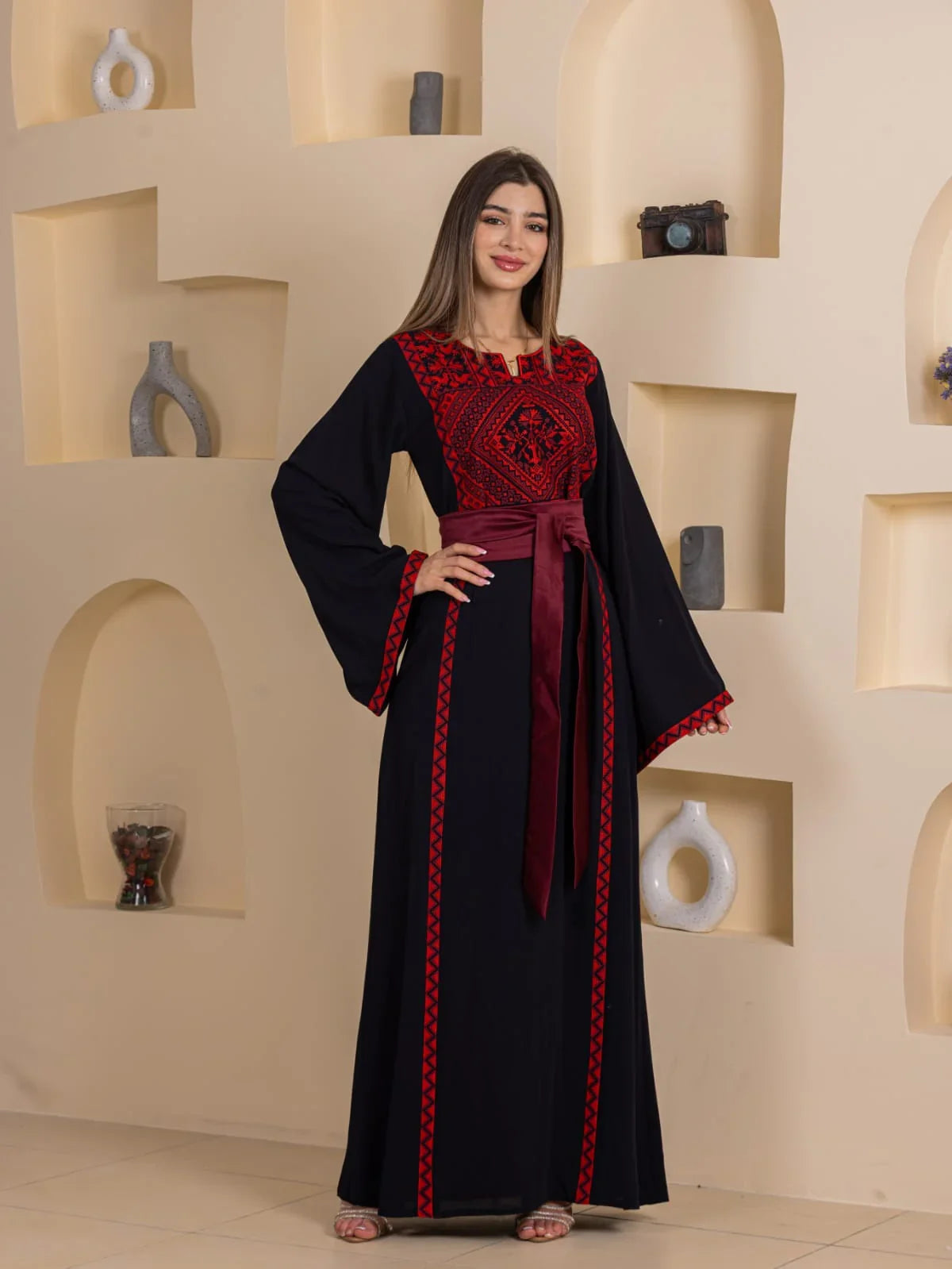 Huda Simply Embroidered Thoub. Palestinian Elegance black thobe with red chest embroidery, wide sleeves and burgundy waist sash