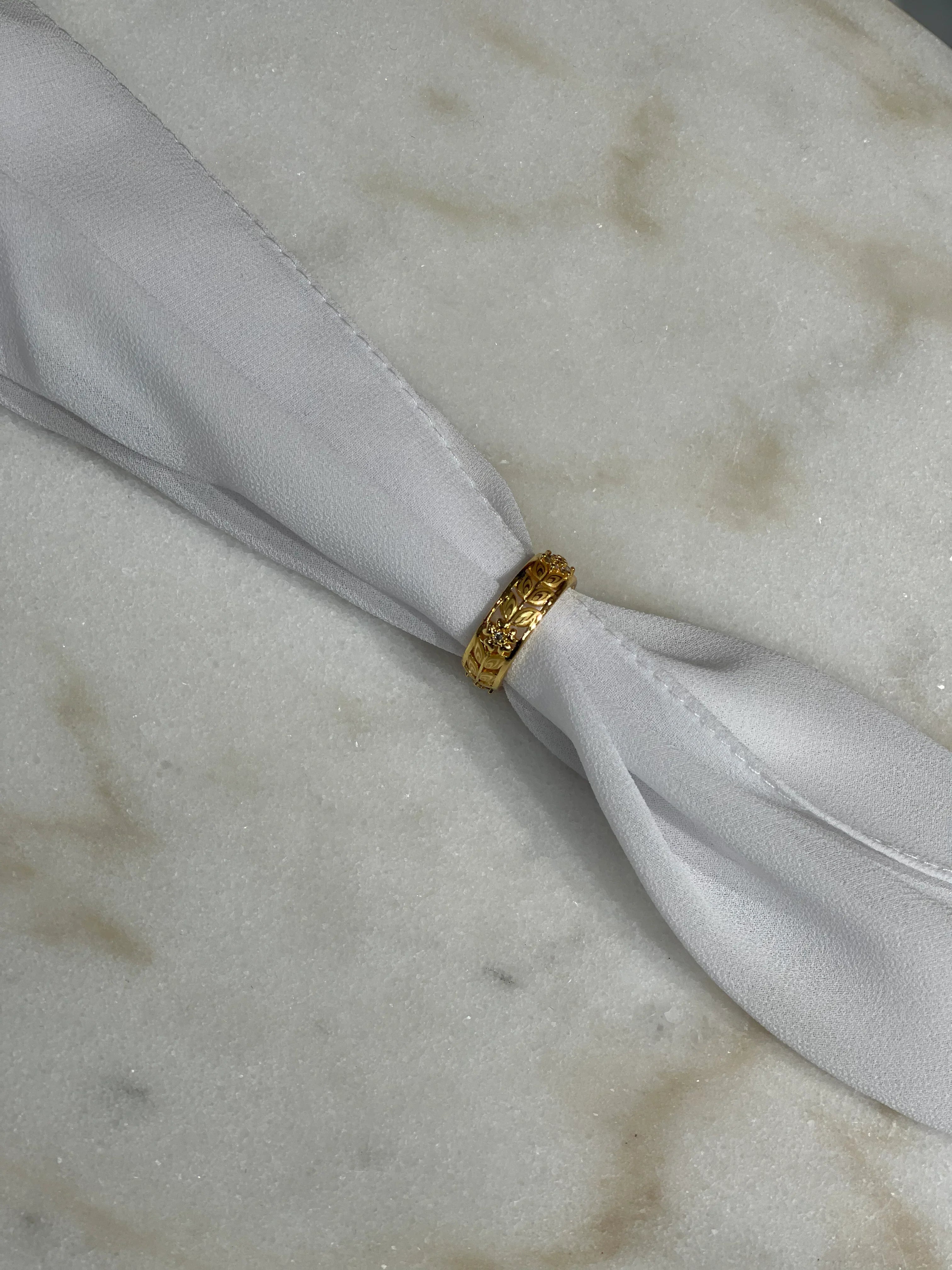 Palestinian Elegance imitated gold bracelet for weddings wrapped around white fabric on marble surface