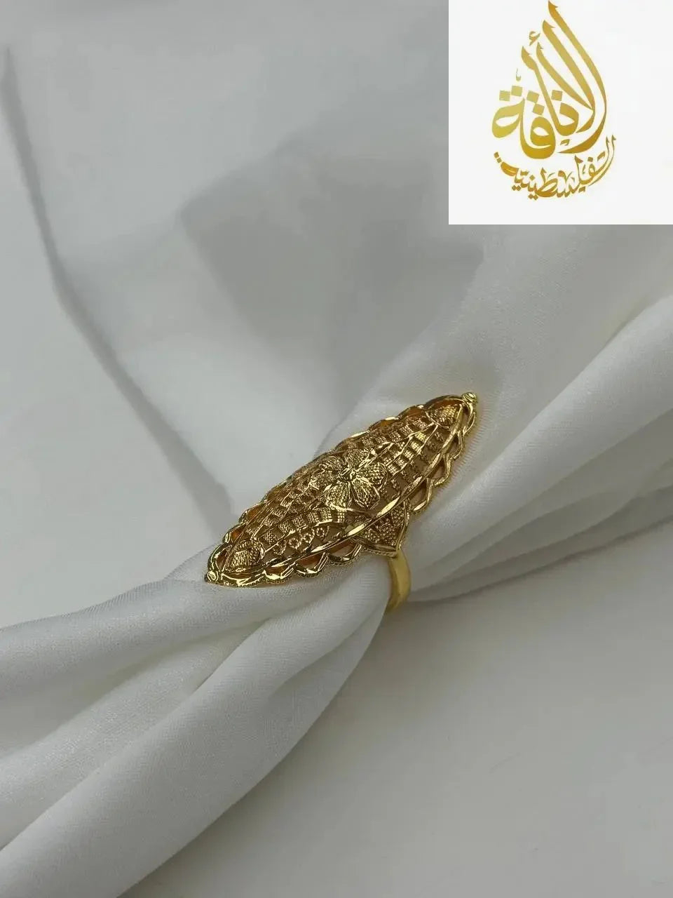 Palestinian Elegance imitated gold ring featuring a unique flower ring design on white fabric