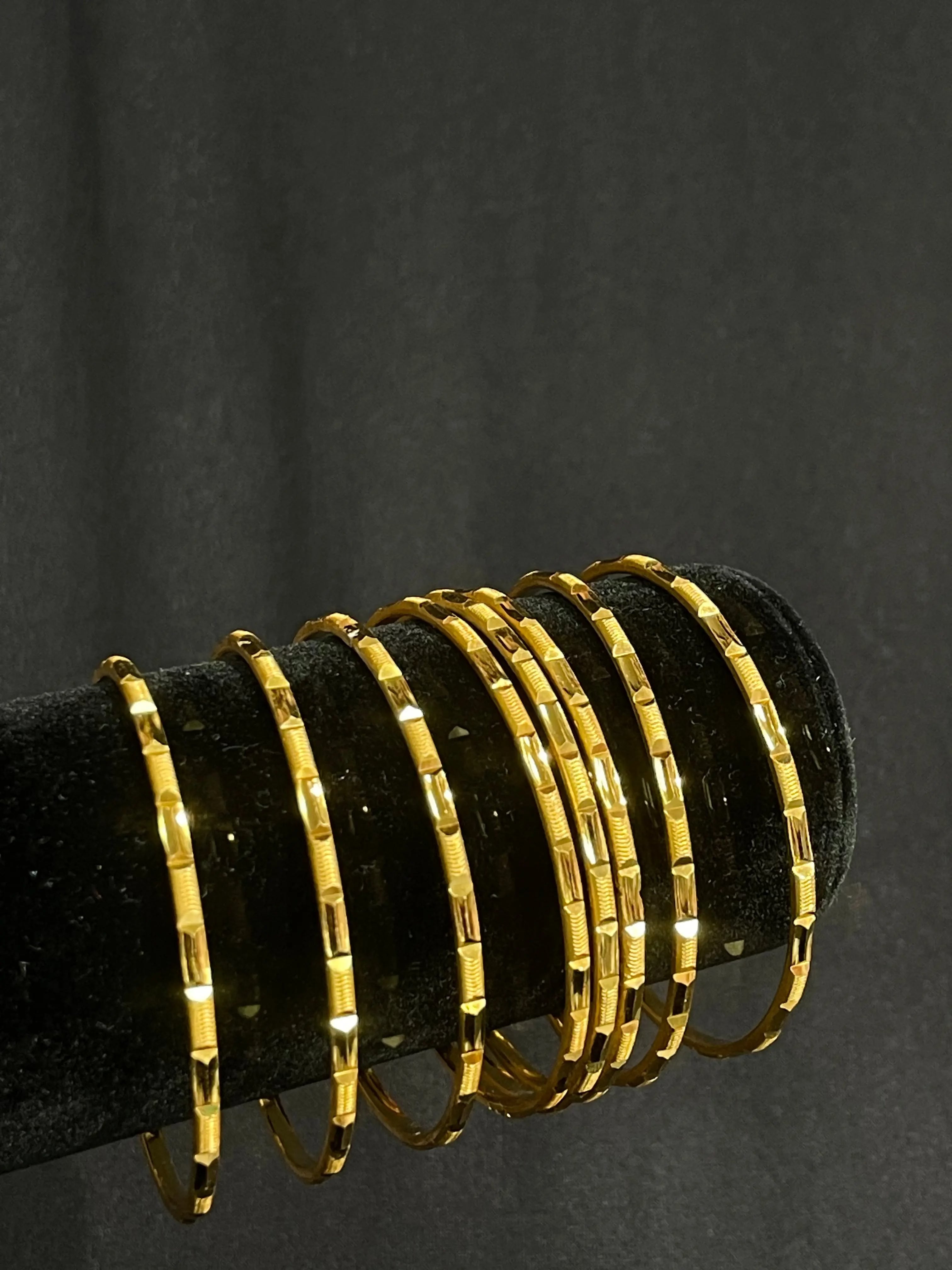 Imitated gold Karmela Thin Bangles displayed on black velvet stand by Palestinian Elegance