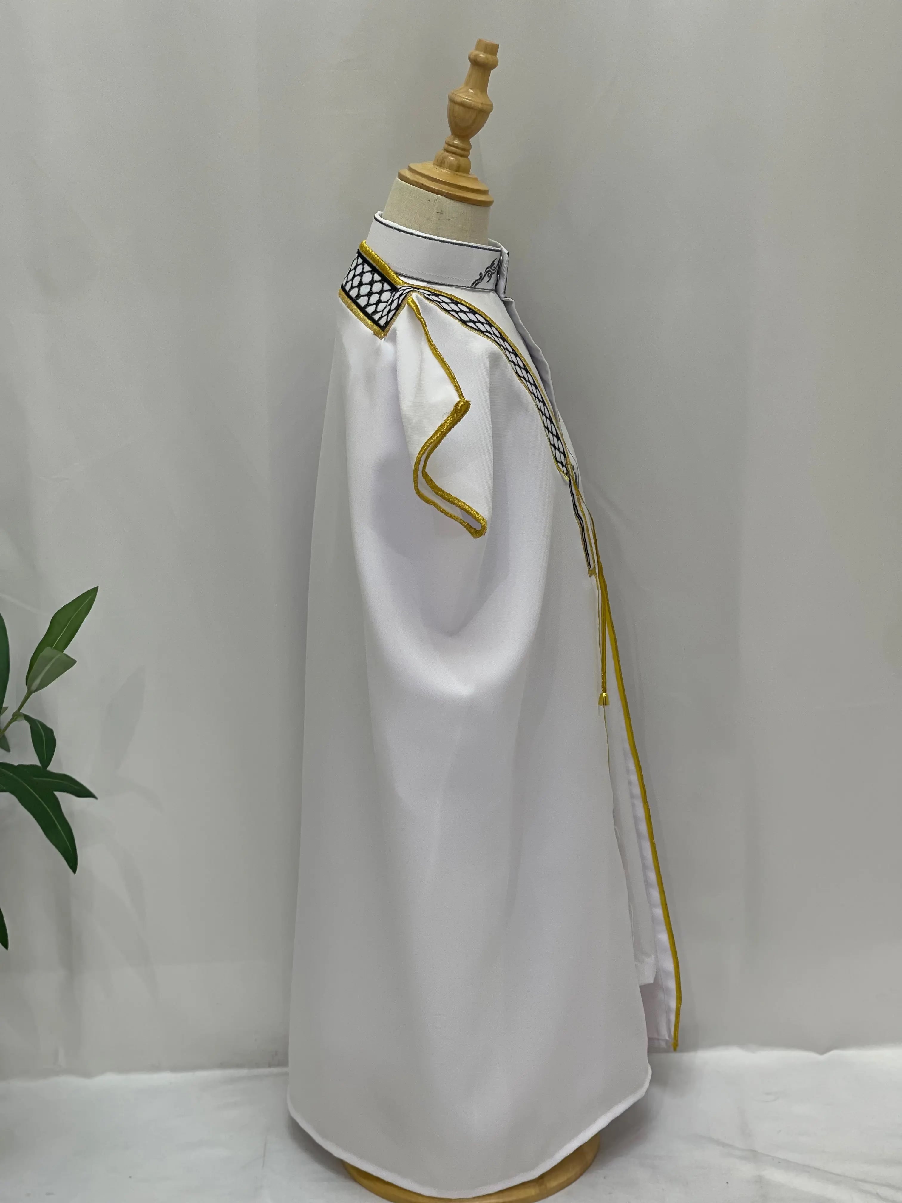 White Kids Kuffiyeh Bisht with gold trim and black and white kuffiyeh detailing on collar by Palestinian Elegance