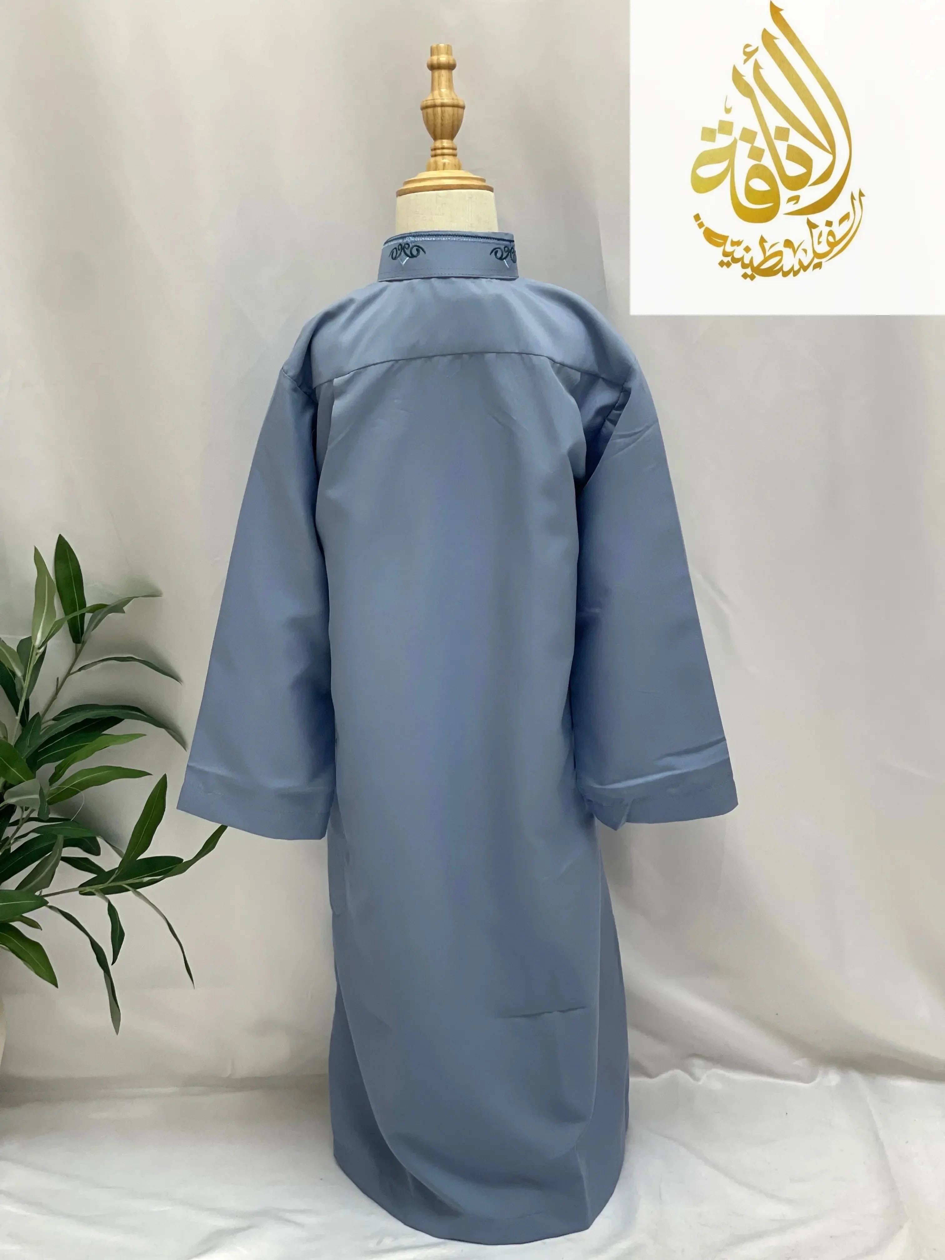 Back view of Palestinian Elegance blue kids embroidered thobe with long sleeves on mannequin