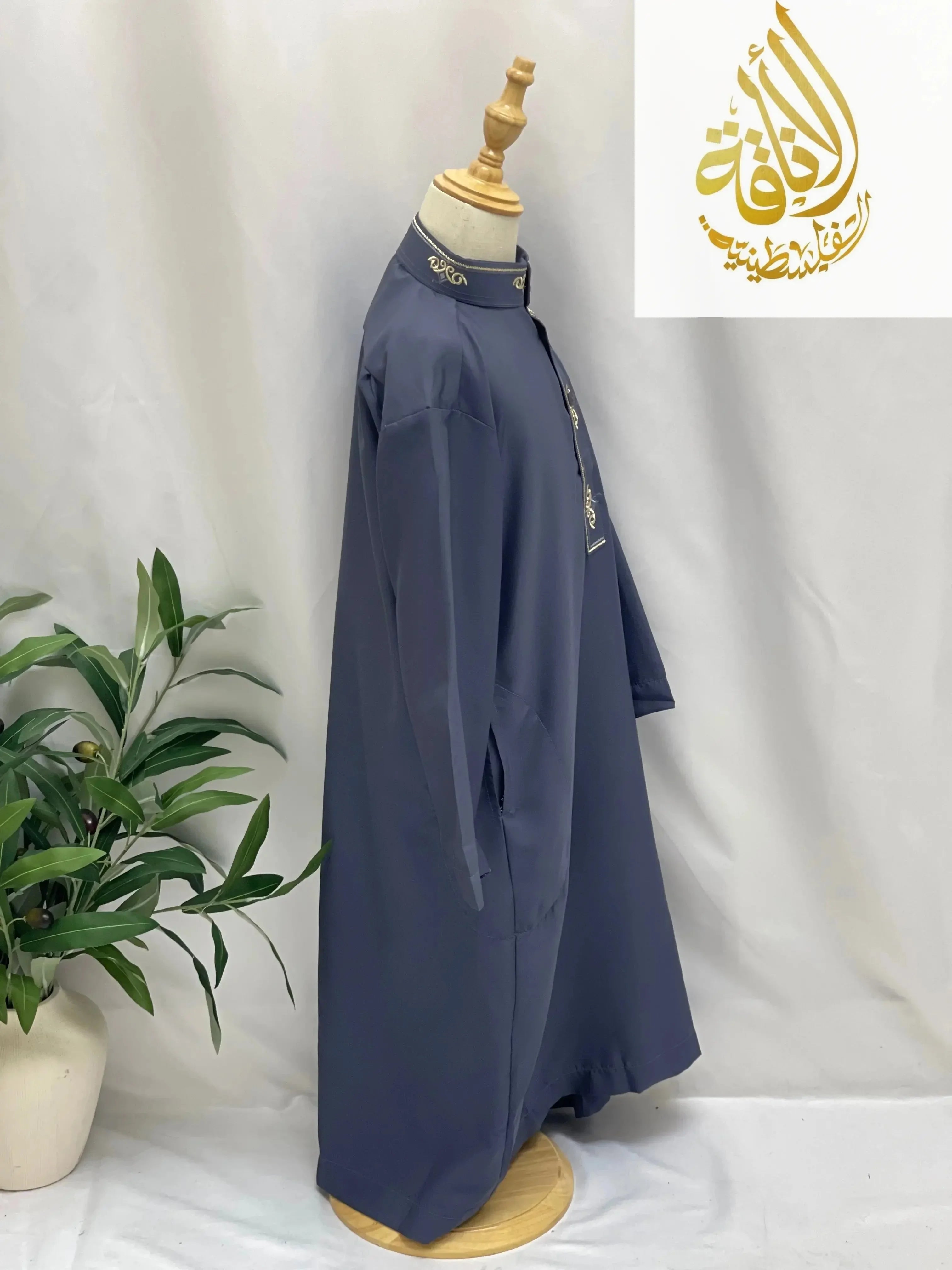 Kids embroidered thobe in navy blue from Palestinian Elegance displayed on a mannequin
