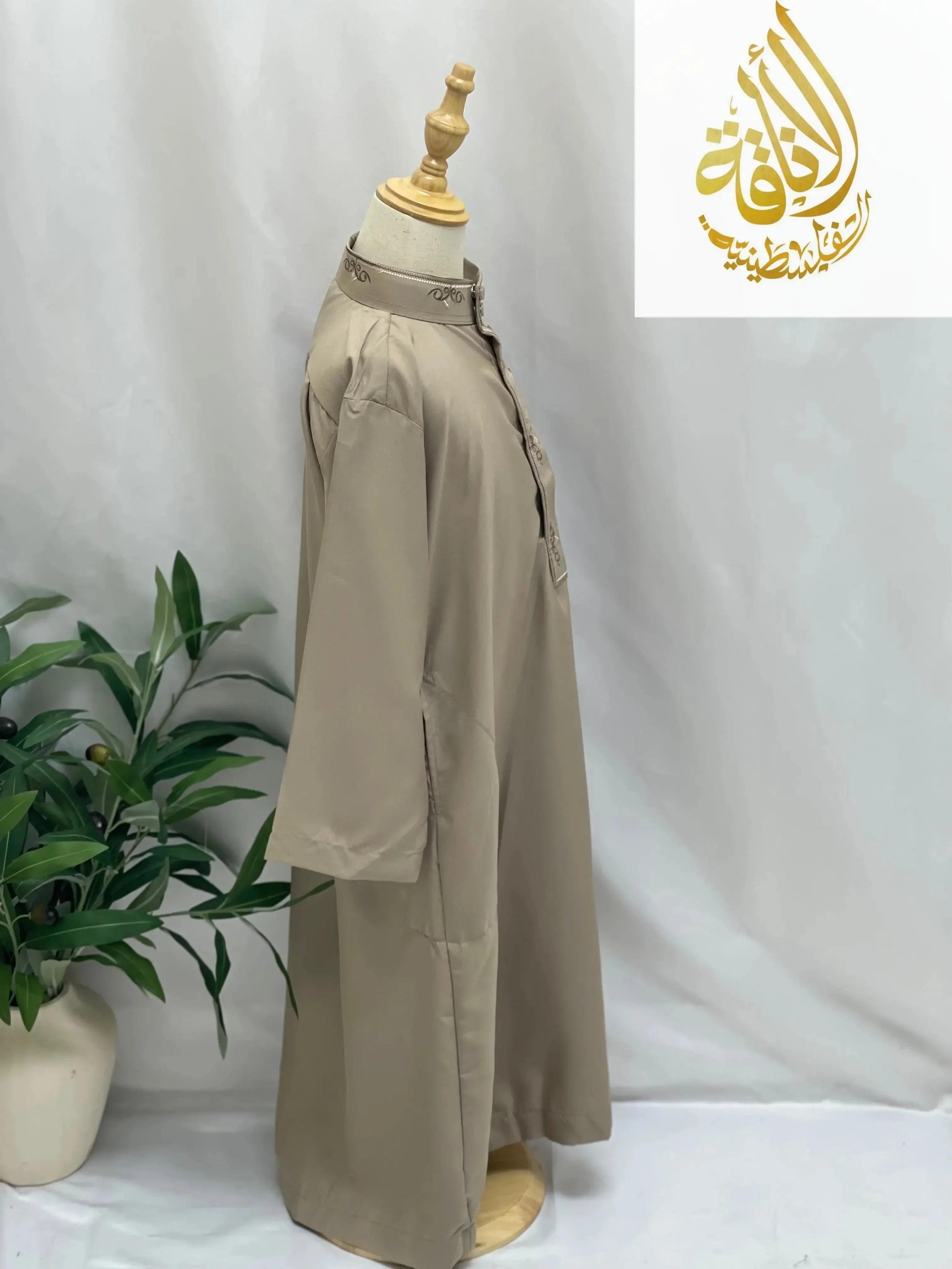 Kids embroidered thobe in beige color displayed on a mannequin by Palestinian Elegance