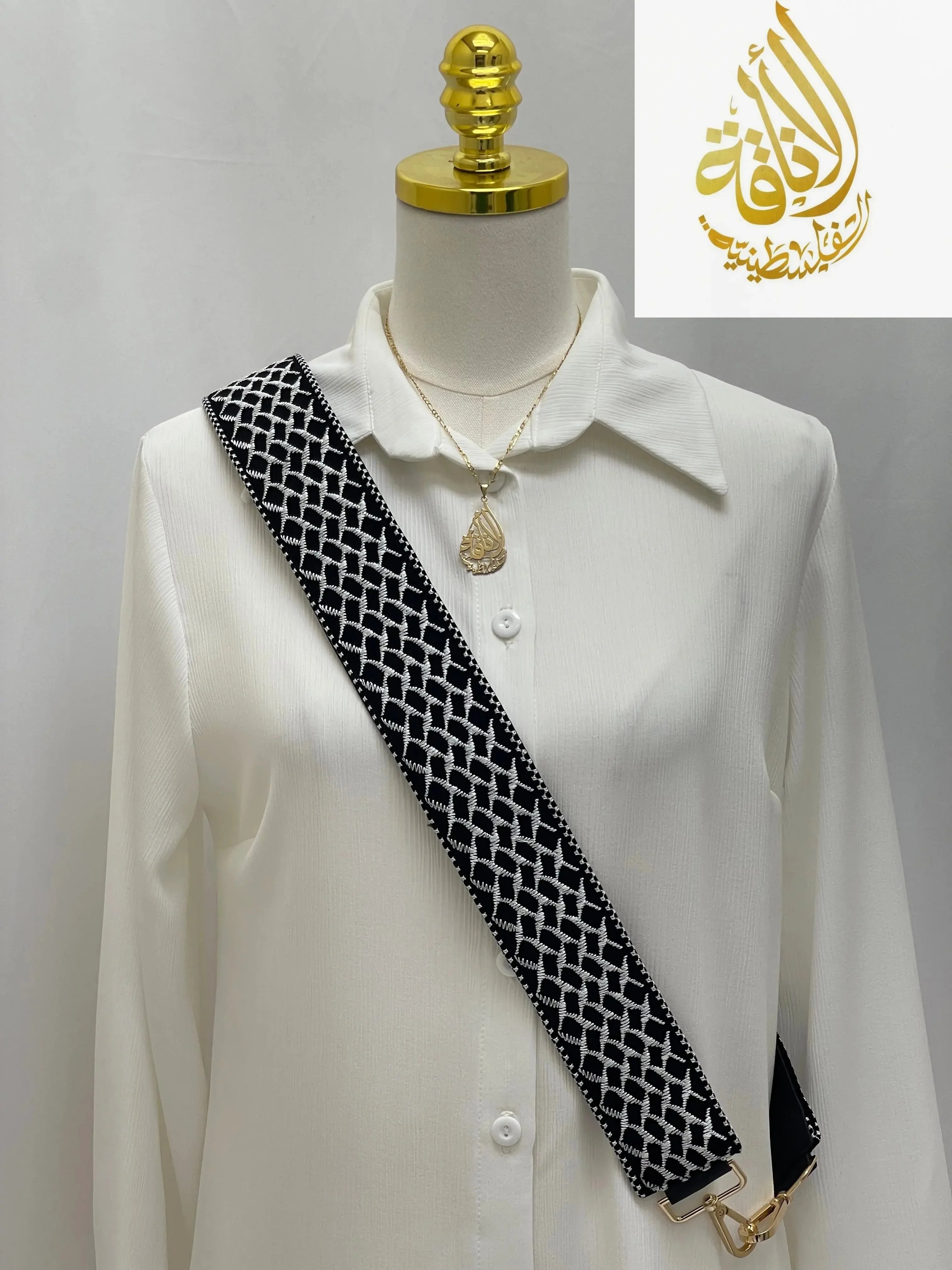 Kuffia Embroidered Purse Strap in black and white geometric pattern displayed on white blouse