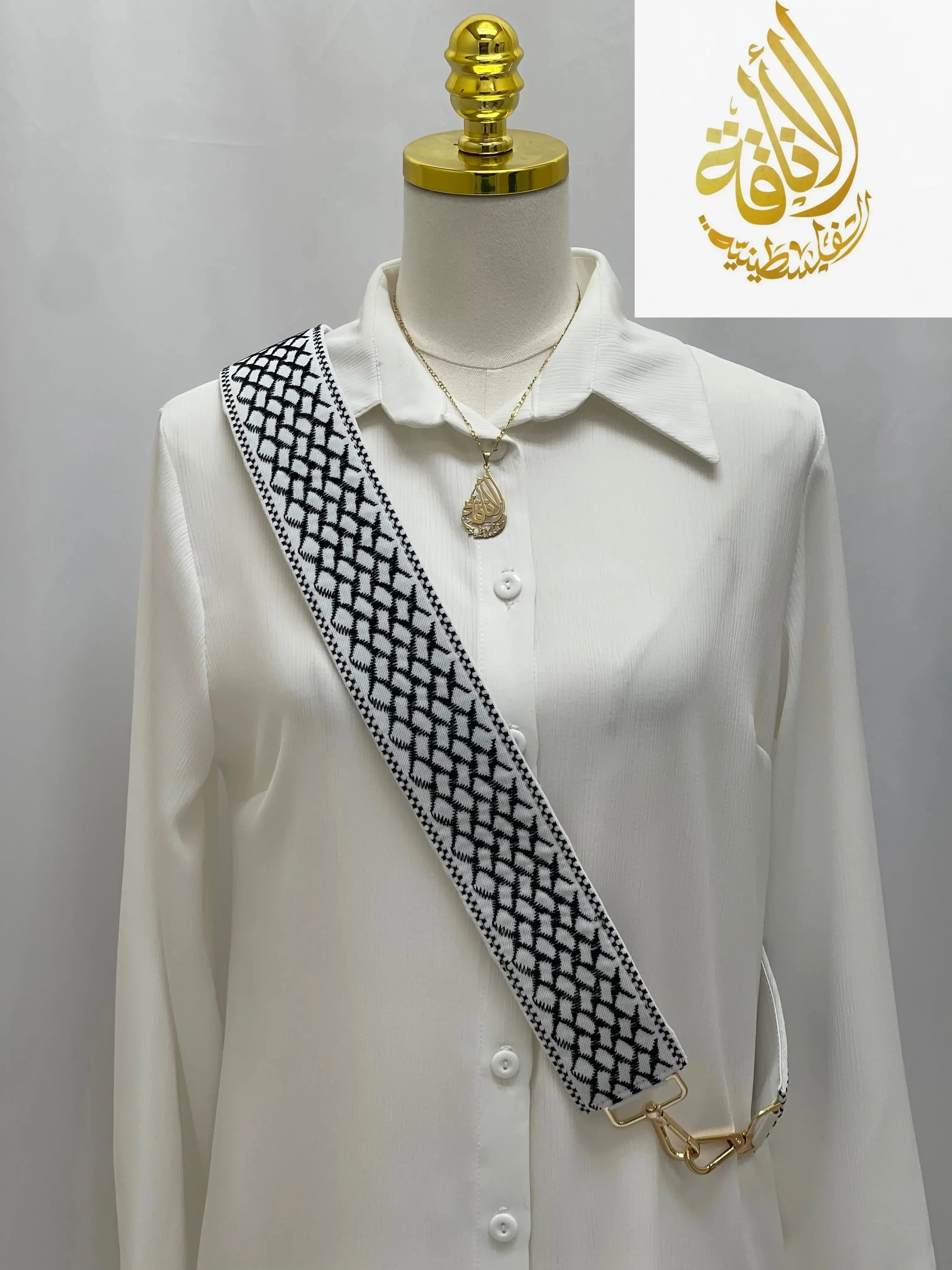 Kuffia Embroidered Purse Strap in black and white geometric pattern by Palestinian Elegance on a white shirt mannequin