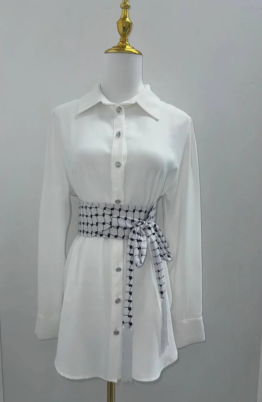 Kufiya Identity Belt in black and white design, styled on a white button-up shirt for a chic look
