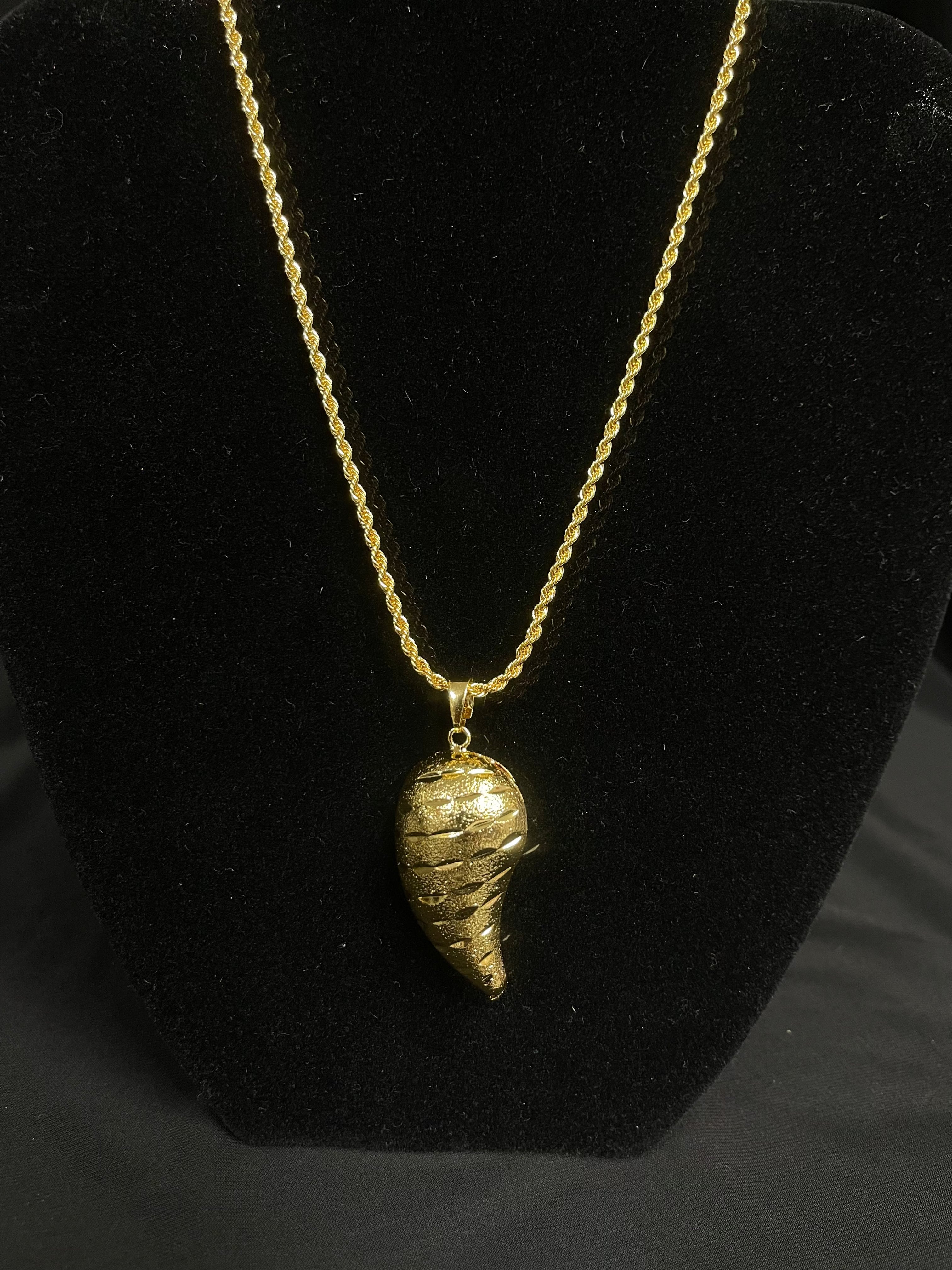 Large Almond Gold Pendant on a gold chain displayed on black velvet stand by Palestinian Elegance