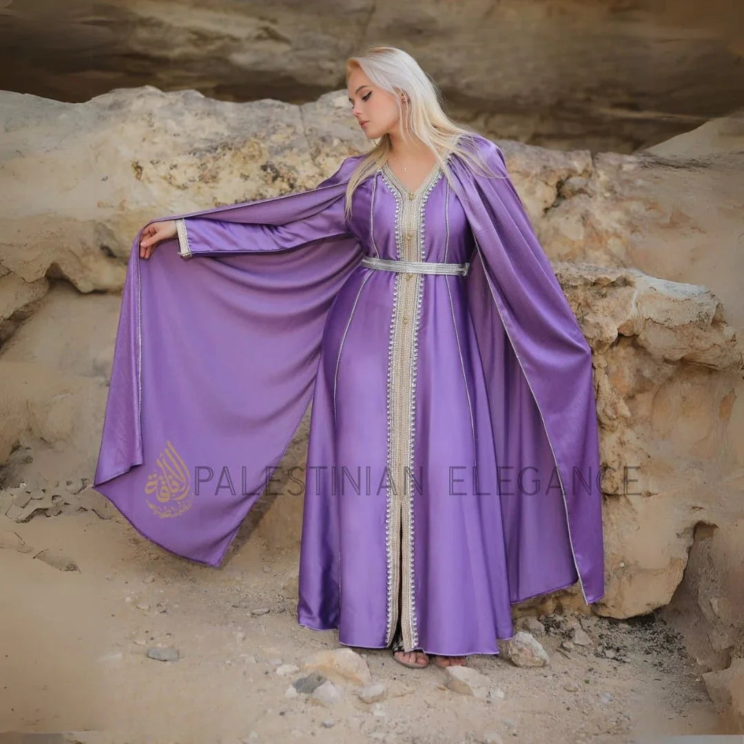 Lilac Moroccan Kaftan Cape by Palestinian Elegance model wearing belted lilac silk kaftan with silver trim and flowing cape