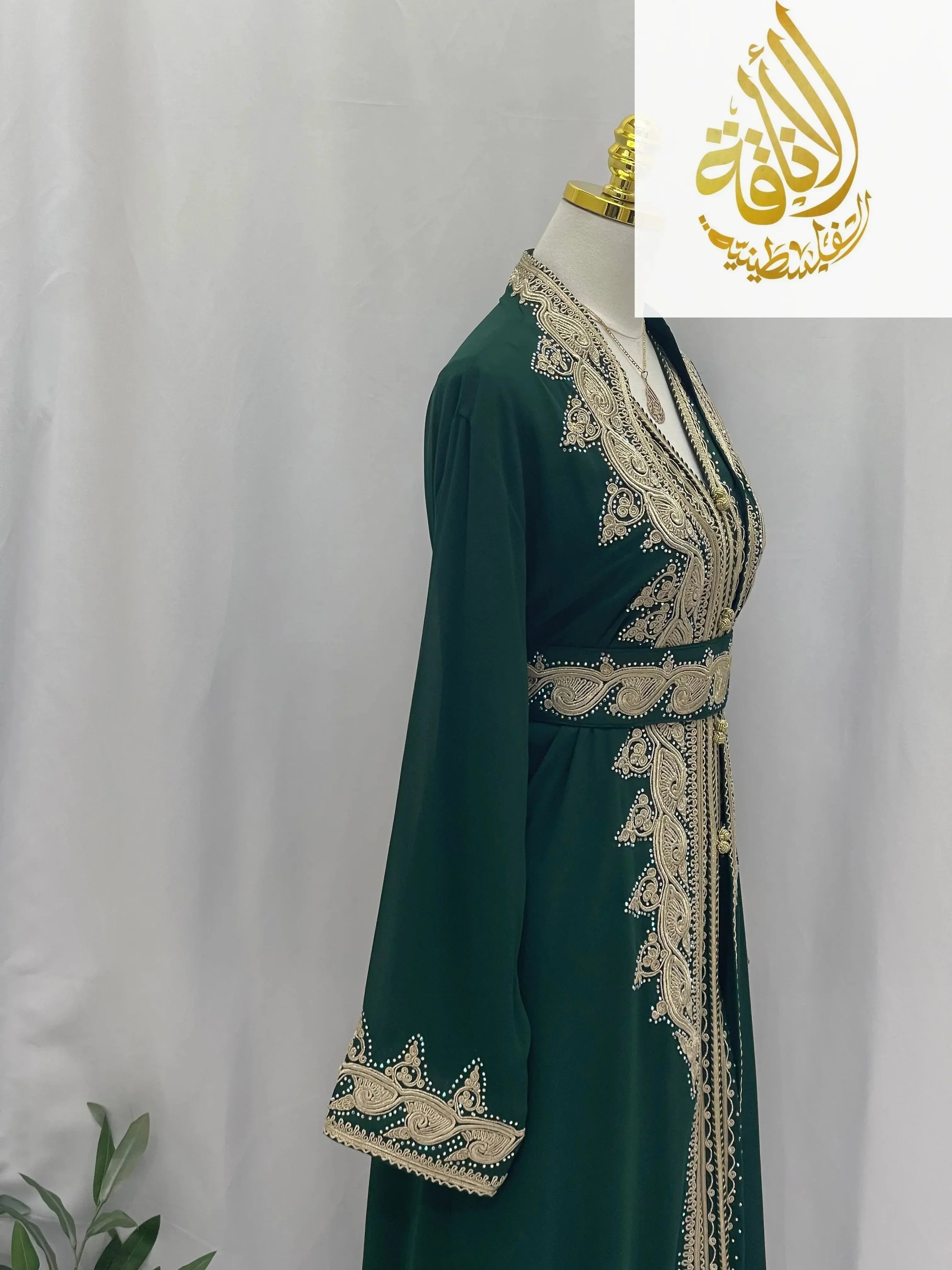Luxurious Alamera kaftan by Palestinian Elegance in deep green with intricate gold embroidery on sleeves and neckline