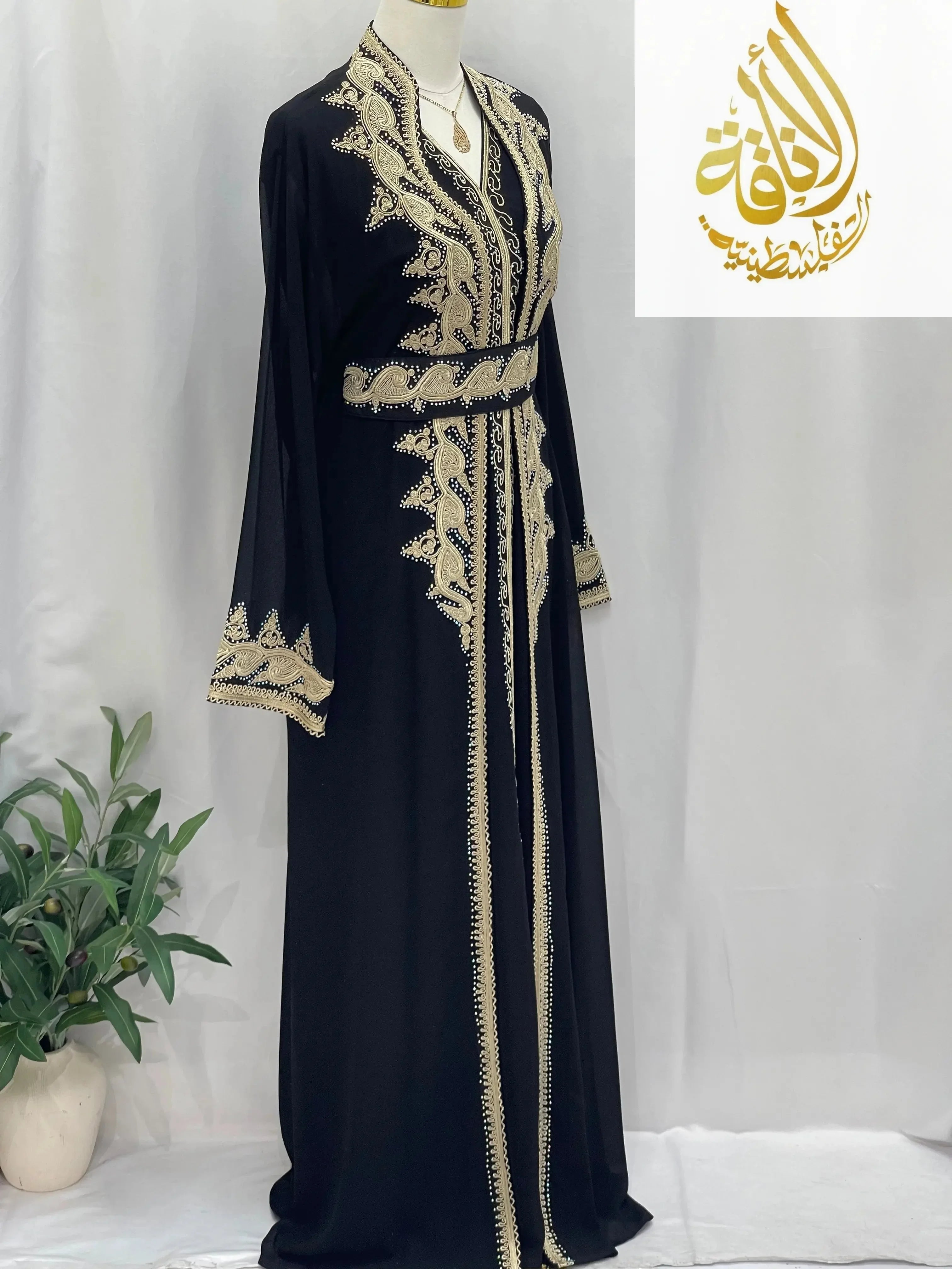 Luxurious Alamera kaftan by Palestinian Elegance in black with intricate gold embroidery and belted waist