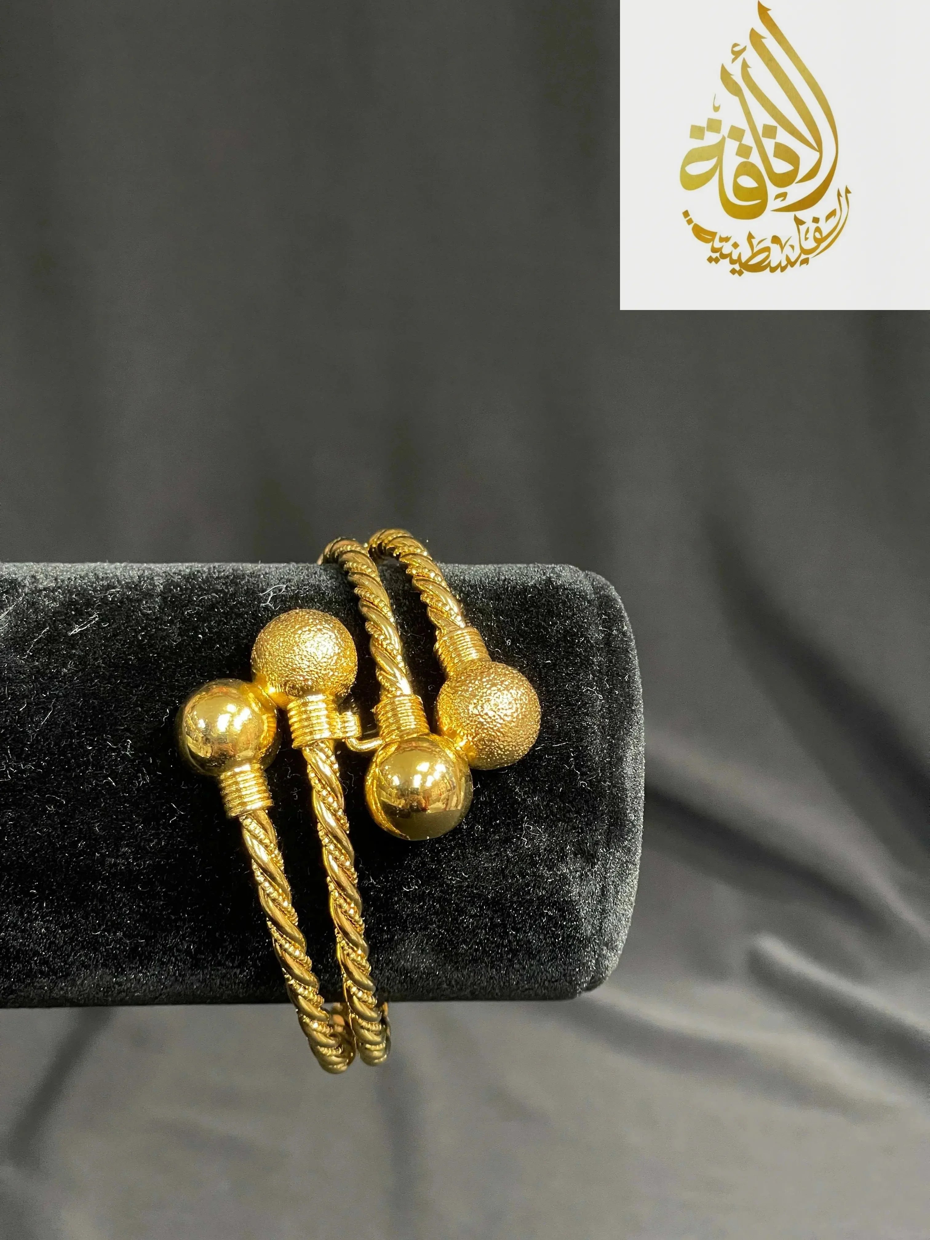 Elegant Mabroma Gold Bracelet by Palestinian Elegance with twisted band and gold textured and smooth ball ends