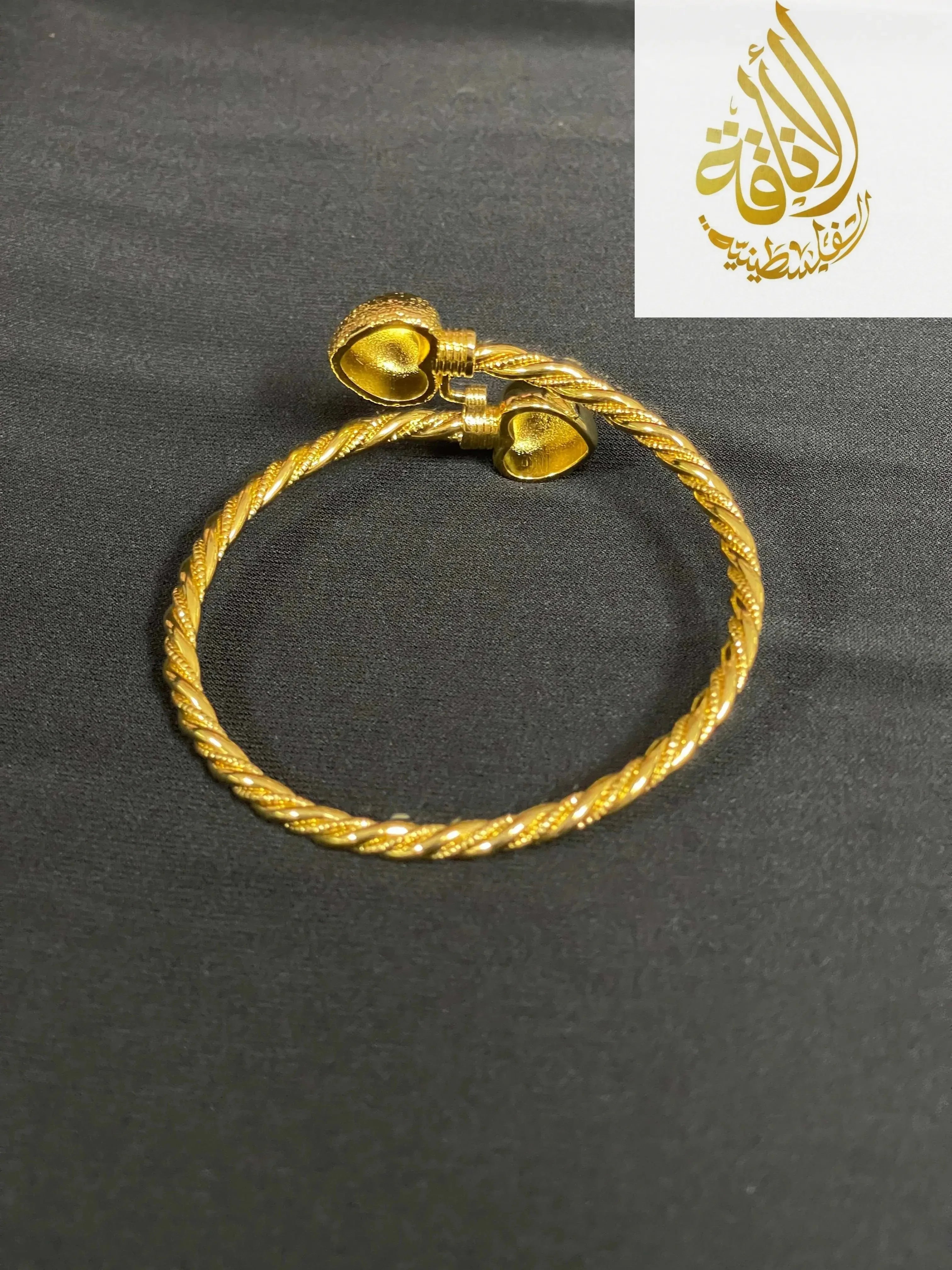 Mabroma Gold Heart Bracelet by Palestinian Elegance with twisted band and heart-shaped ends