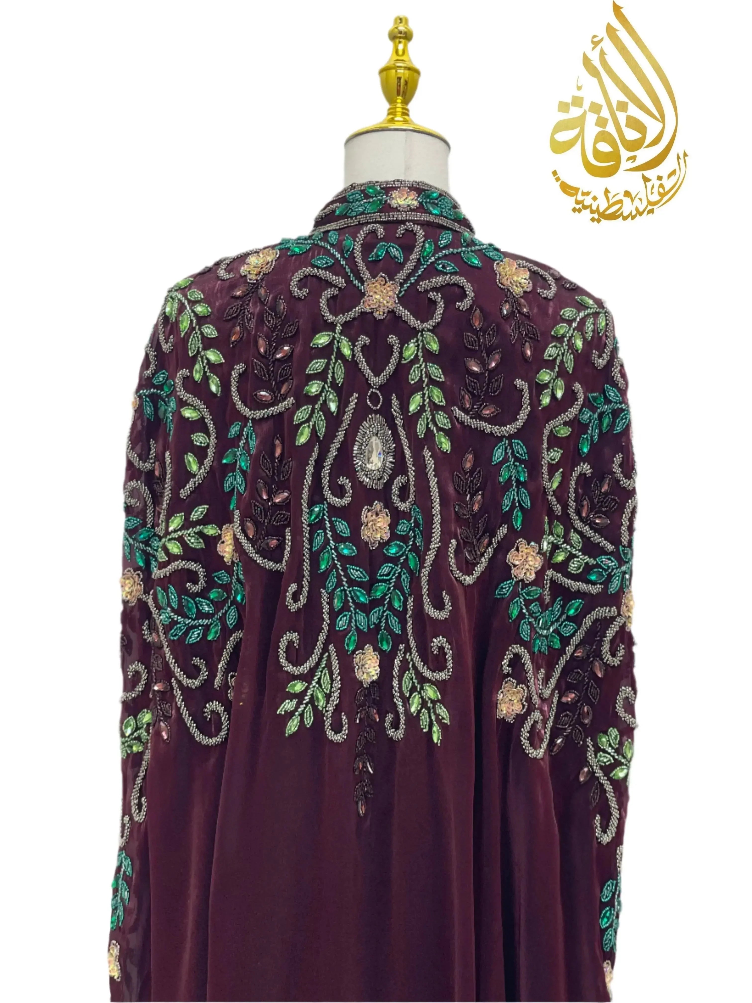 Palestinian Elegance Luxury Bejeweled Cape abaya with intricate green and gold floral embroidery on deep purple fabric