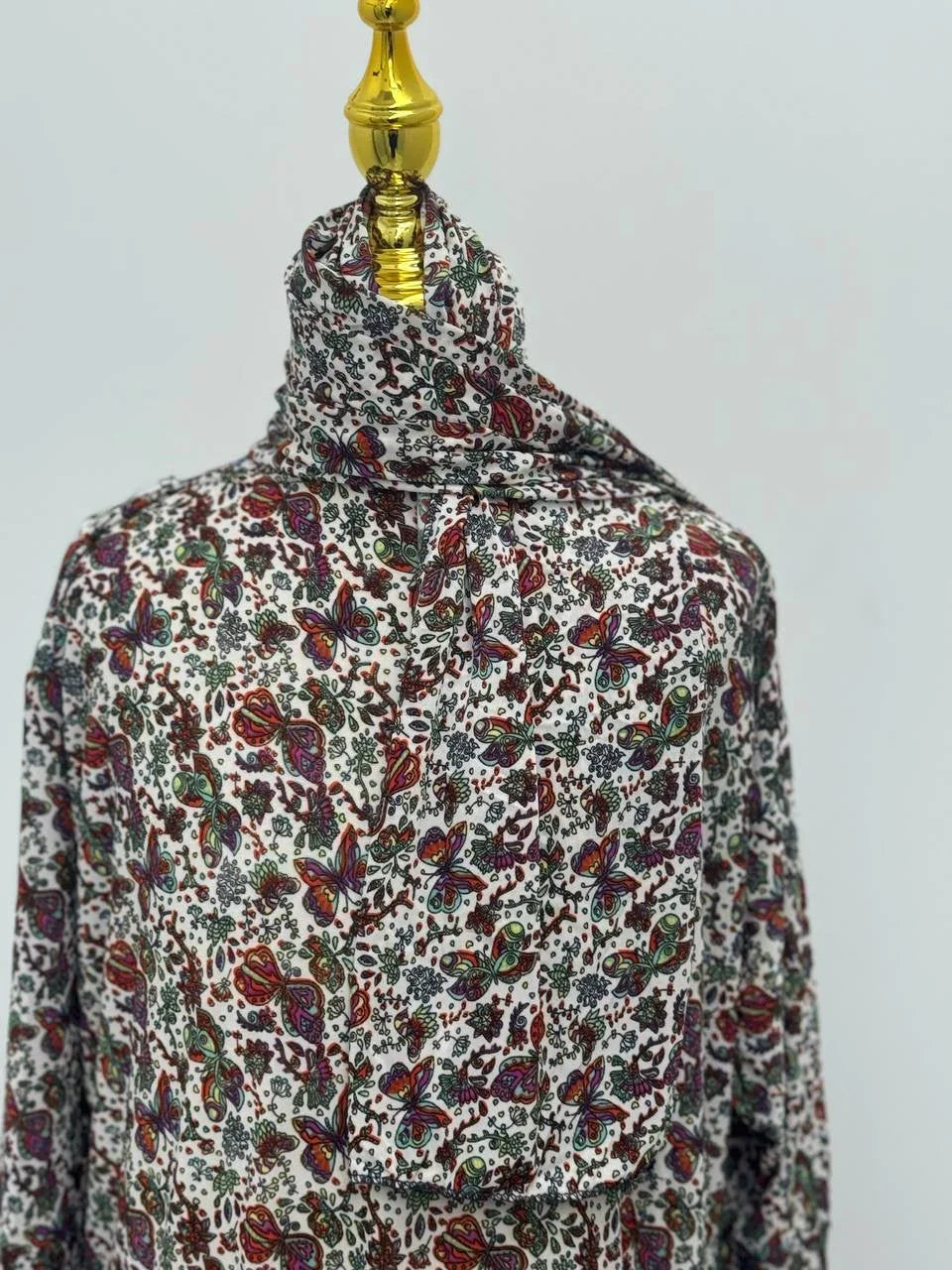 Palestinian Elegance Full Prayer Dress in cream paisley floral print draped on mannequin with head covering