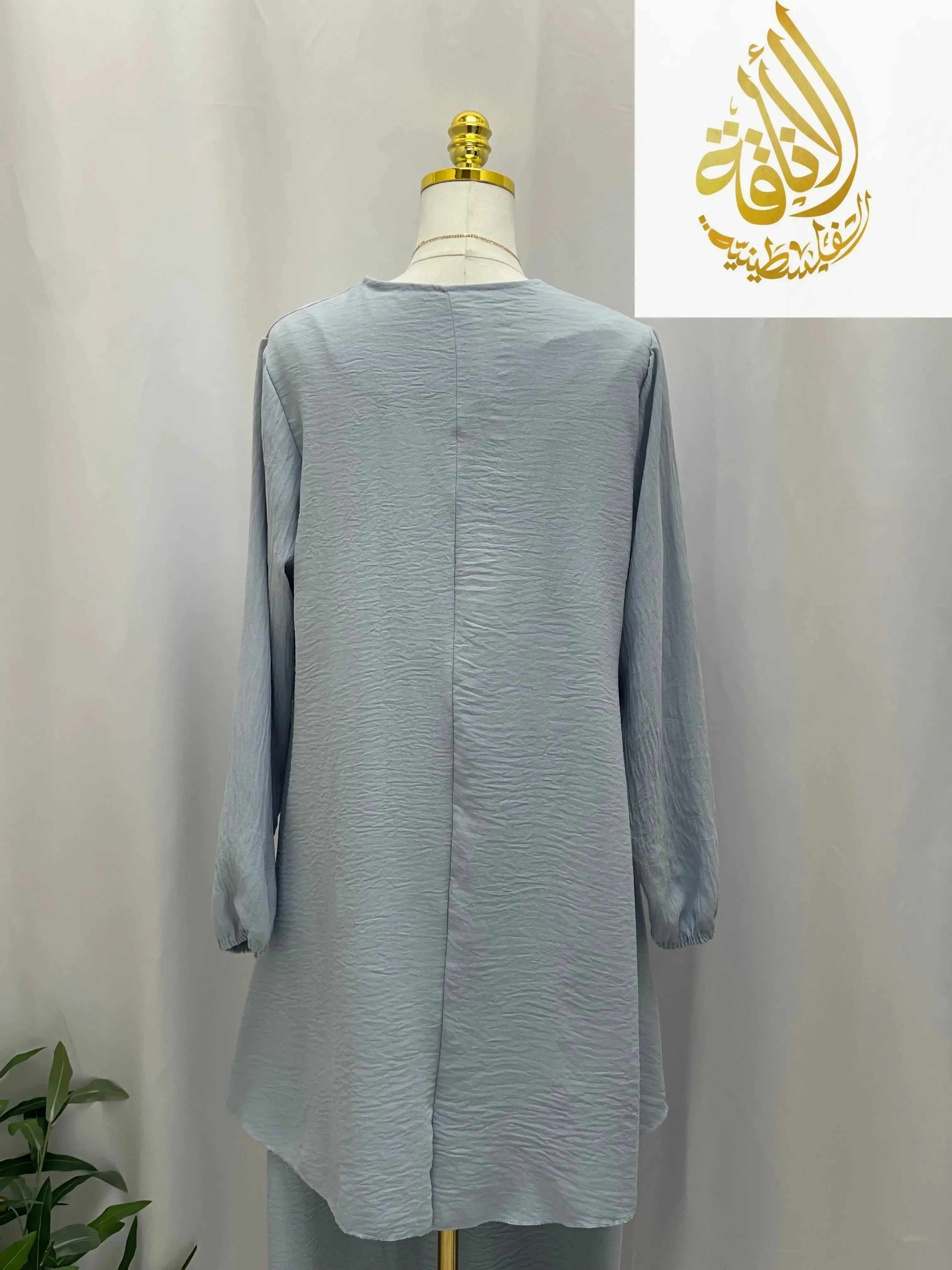 Back view of modest long tunic and pant set in light blue textured fabric by Palestinian Elegance