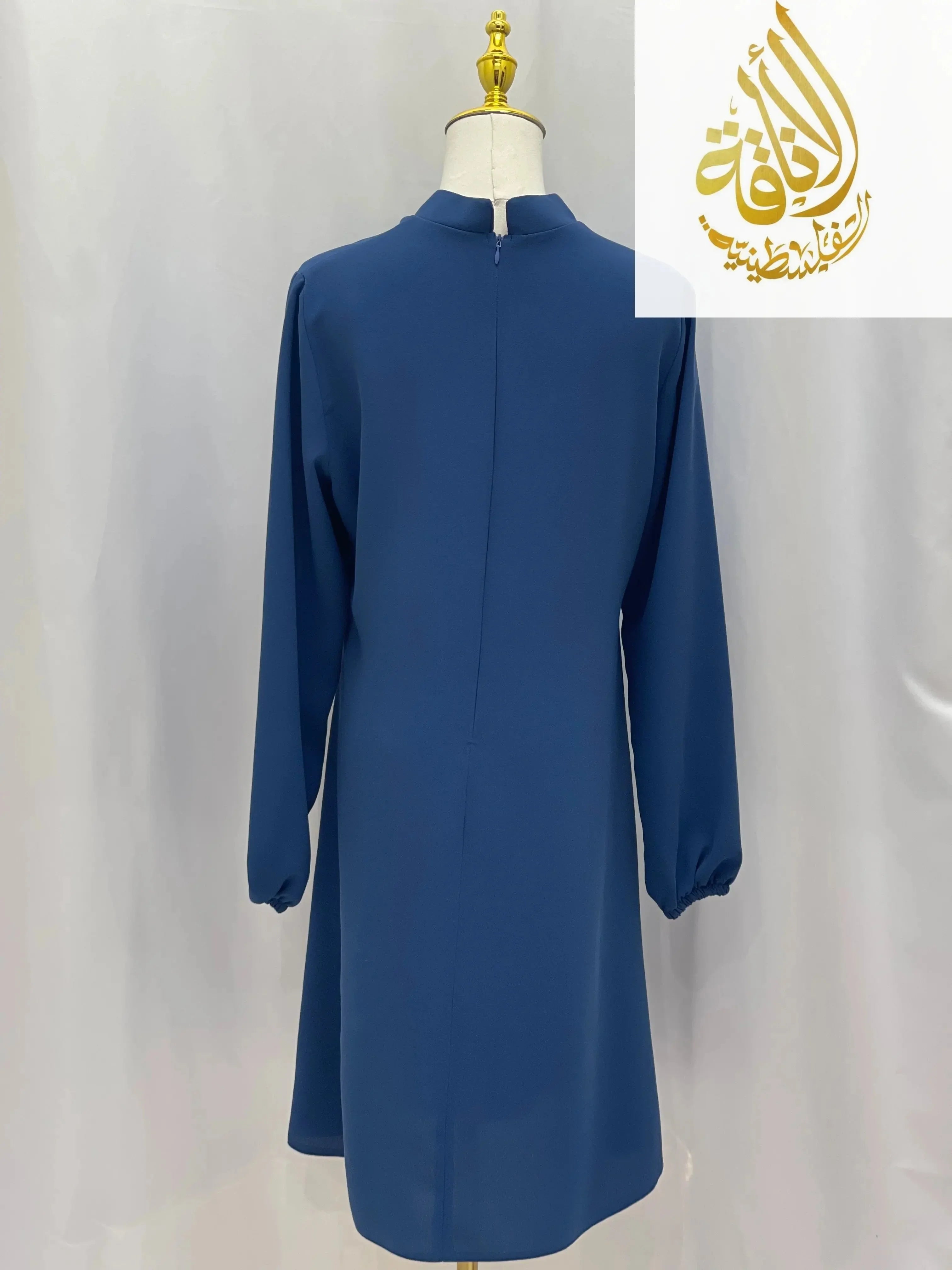Back view of blue modest embroidered tunic dress with long sleeves and zipper closure