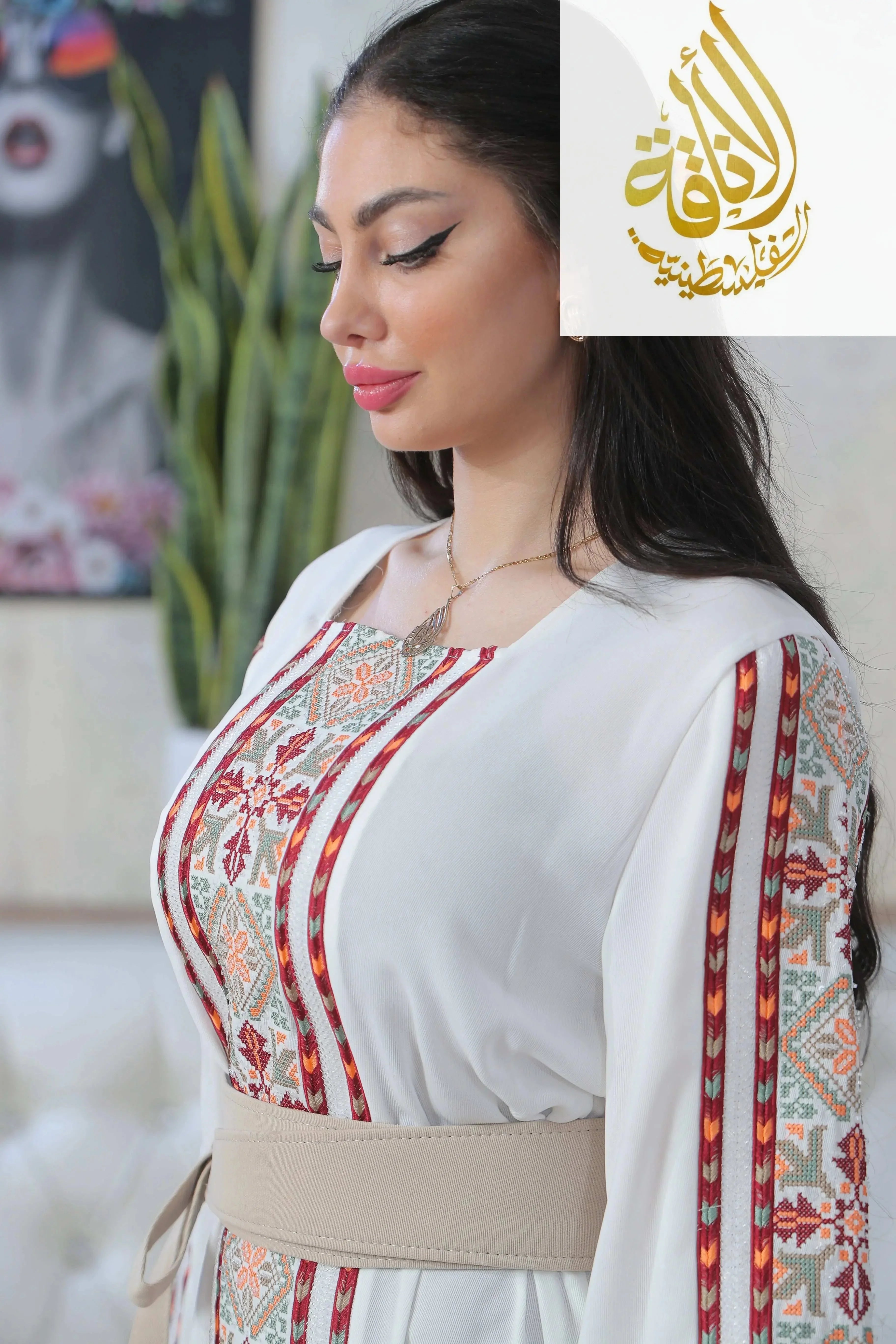 Palestinian Elegance Nadera Embroidered Thoub with traditional red and beige geometric patterns on white fabric