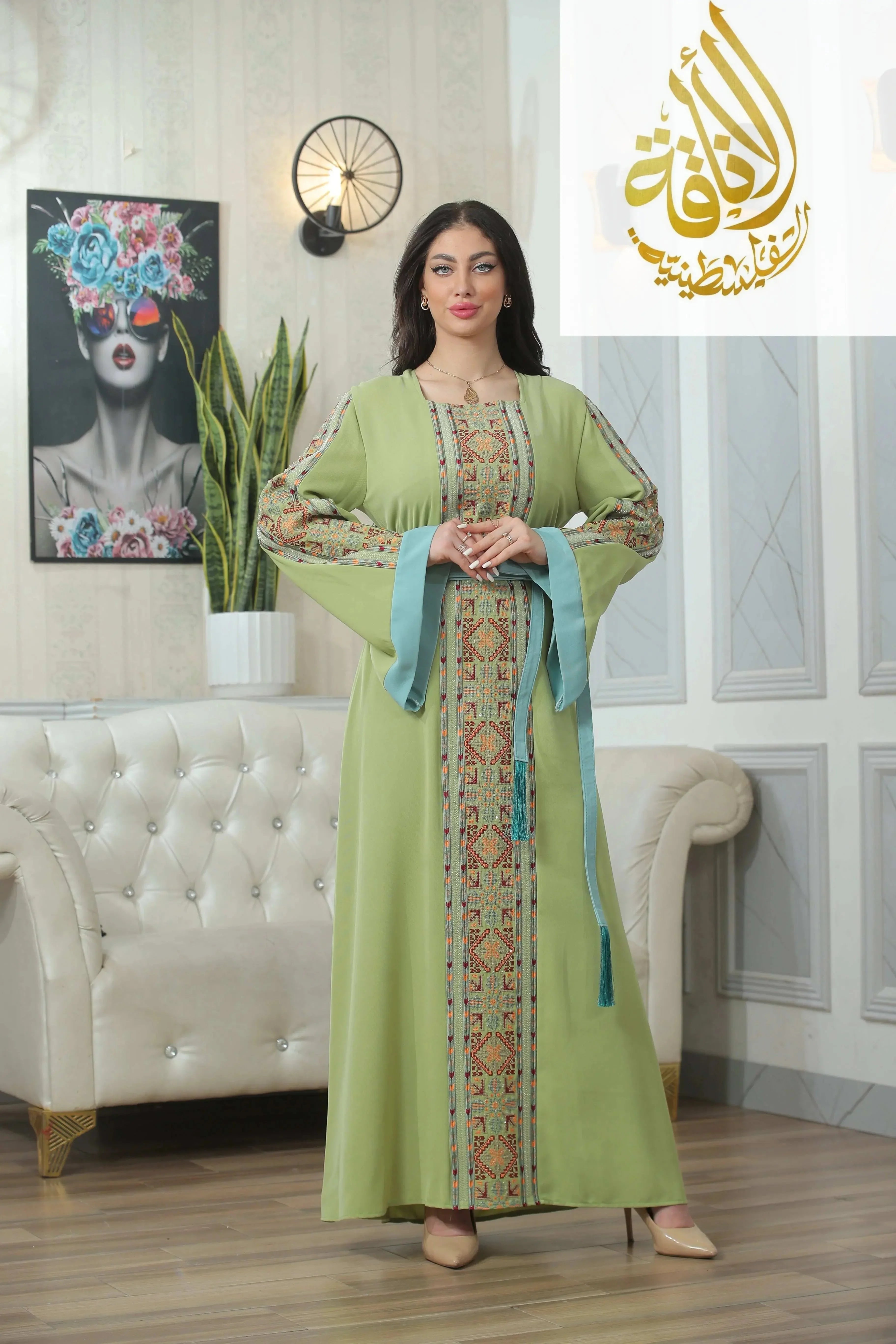 Palestinian Elegance Nadera Embroidered Thoub in light green with intricate embroidery and blue sash