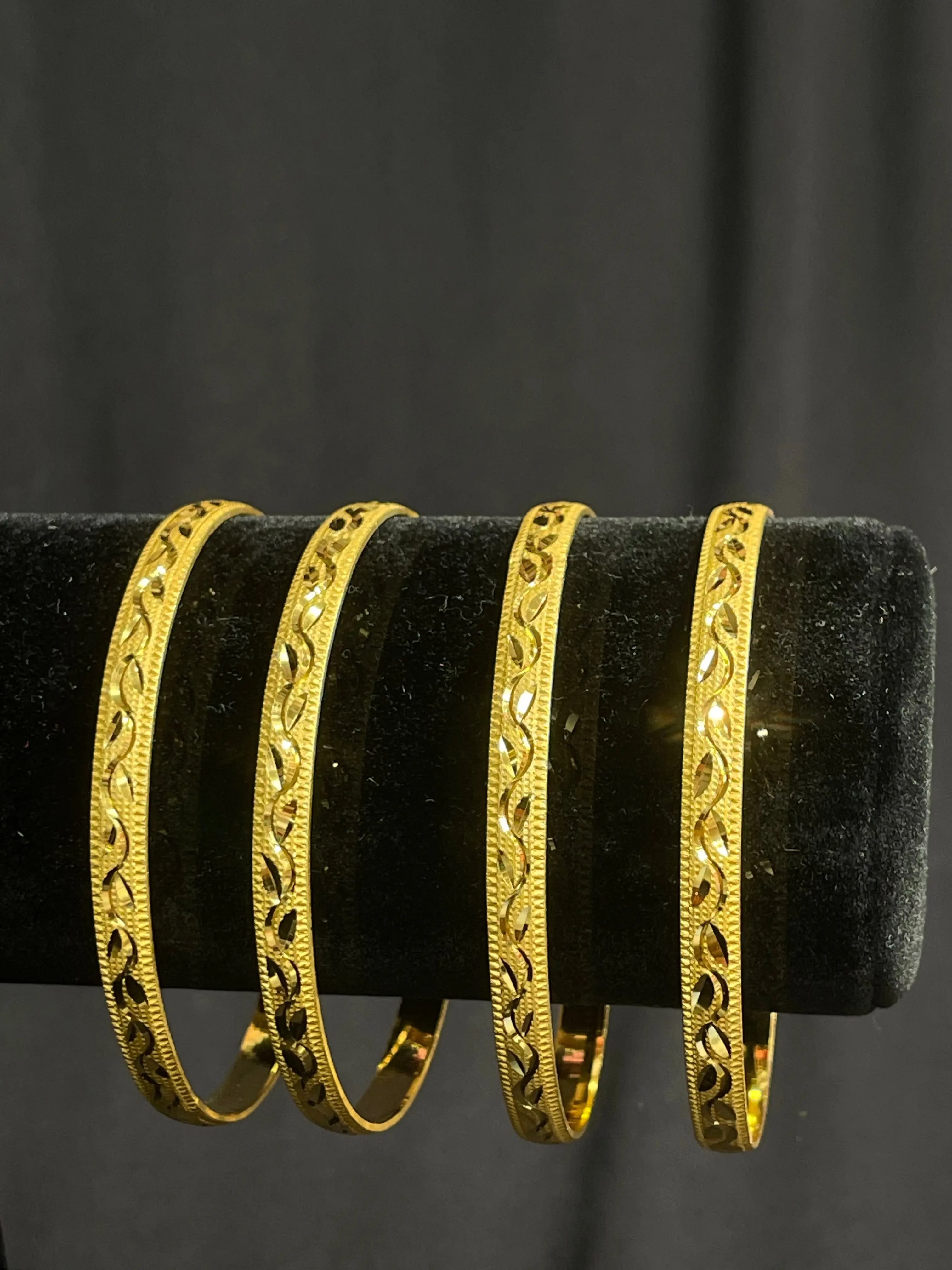Najwa Bangles with imitated gold design displayed on black velvet stand by Palestinian Elegance