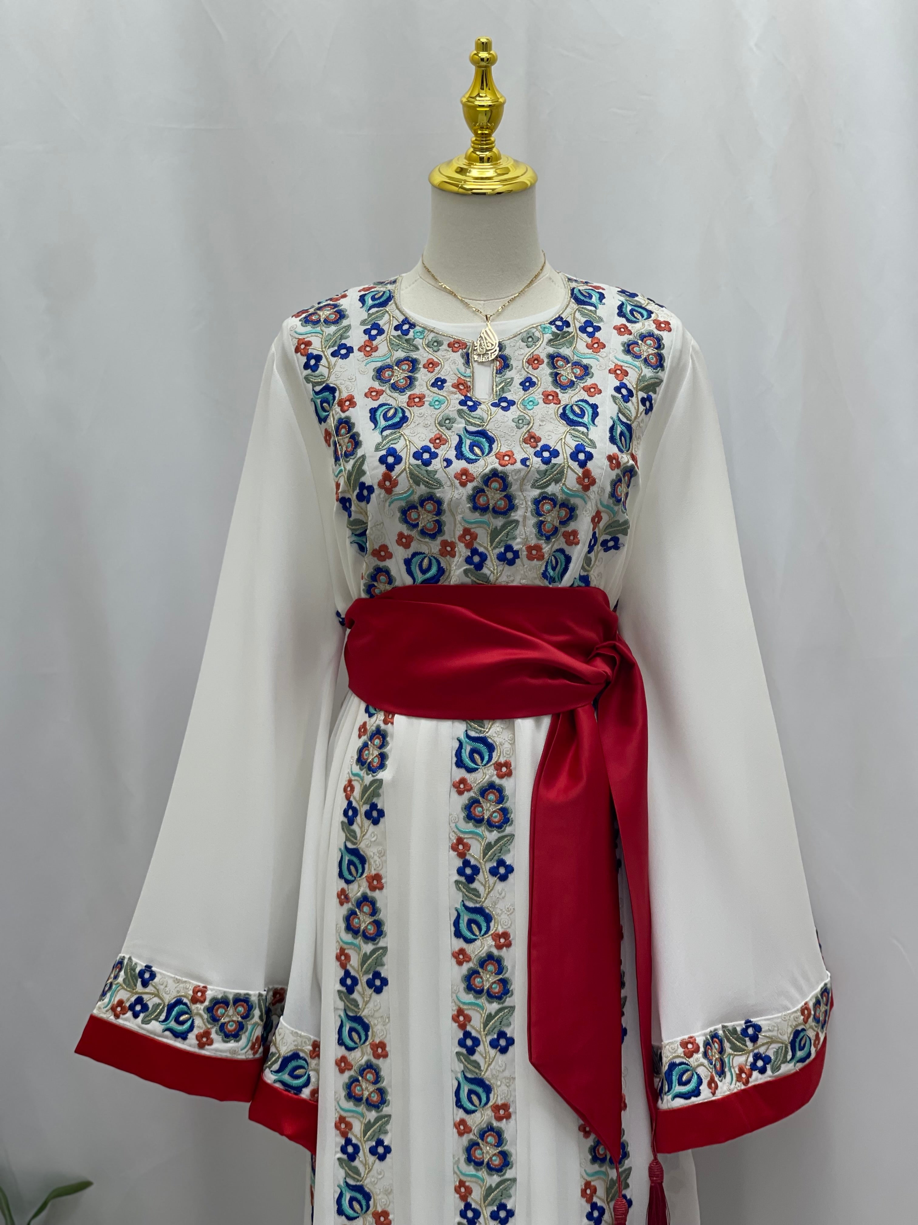 Palestinian embroidered dress by Palestinian Elegance with colorful floral embroidery and red sash belt