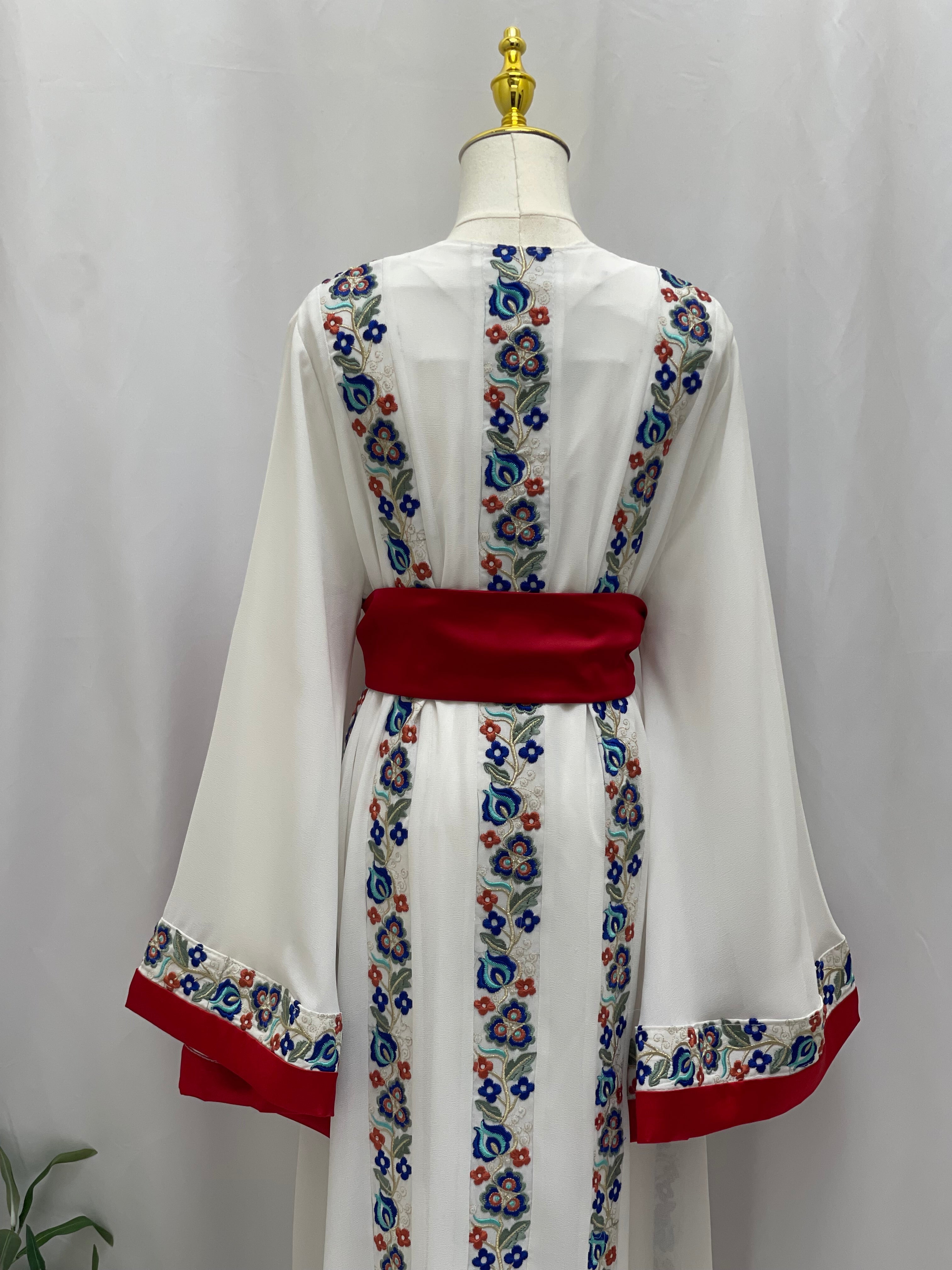 White Palestinian embroidered dress with colorful floral embroidery and red waist belt by Palestinian Elegance