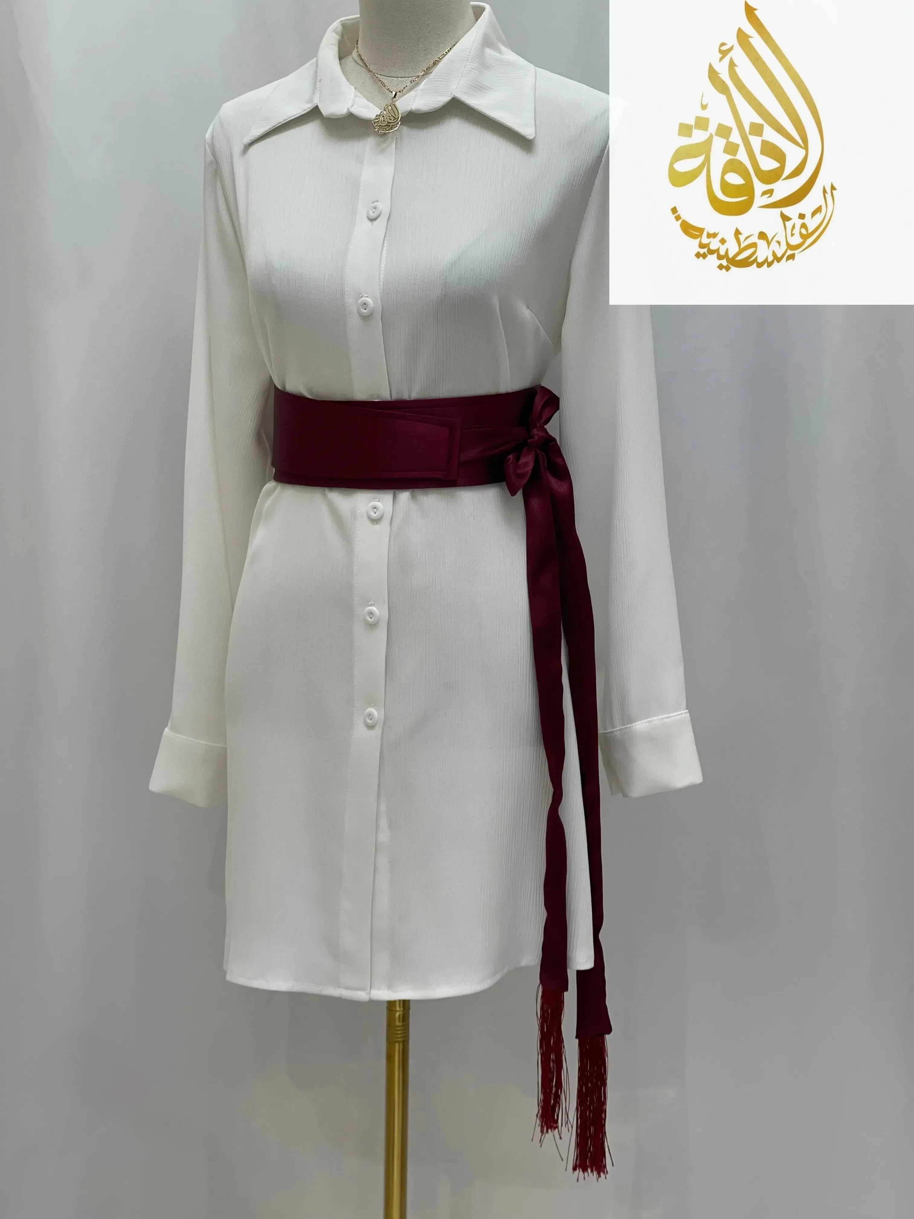 Satin belt for dresses in deep burgundy tied around white shirt dress by Palestinian Elegance