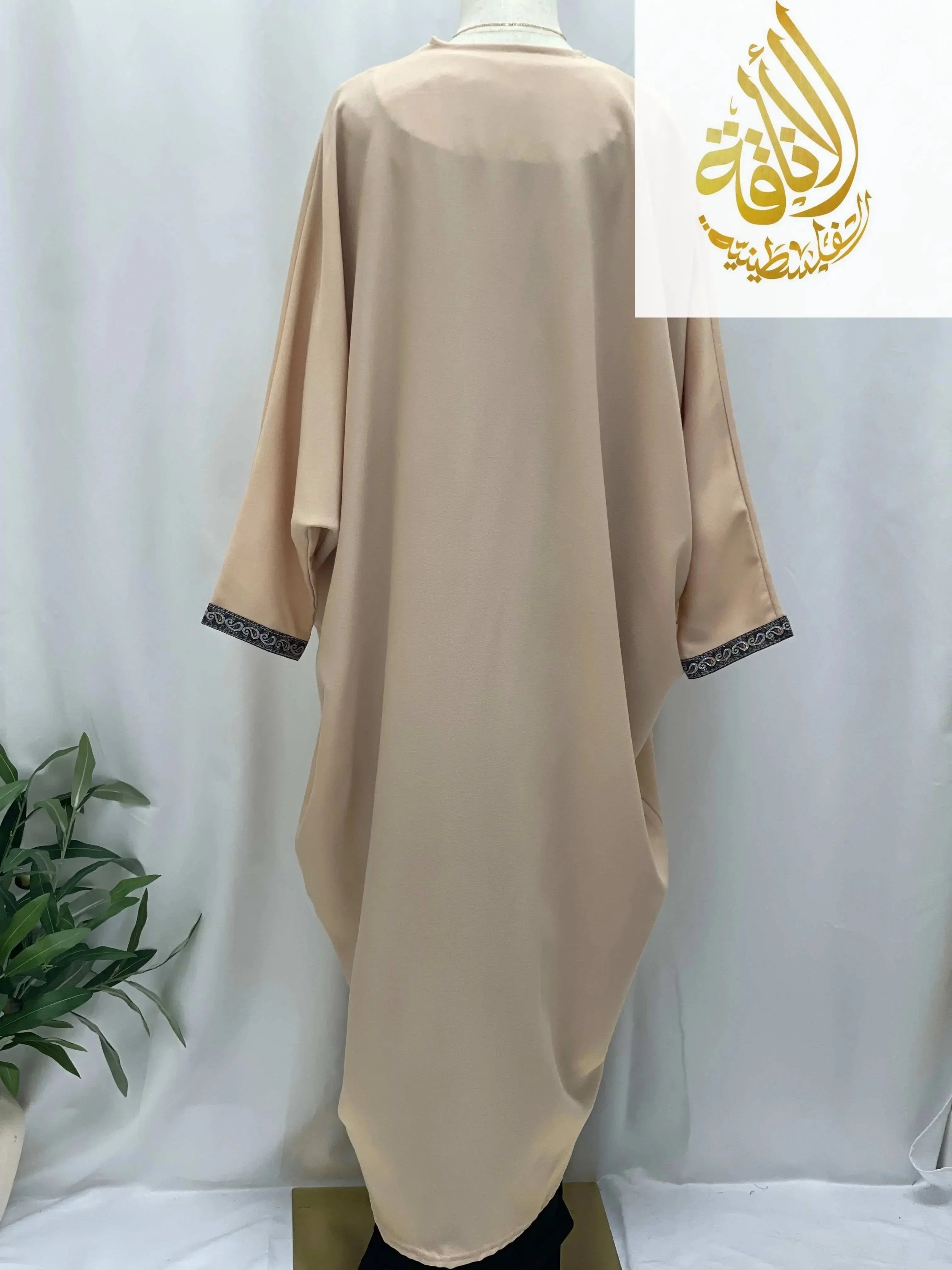 Back view of Nijma Free Size kimono cardigan by Palestinian Elegance in beige with decorative sleeve trim