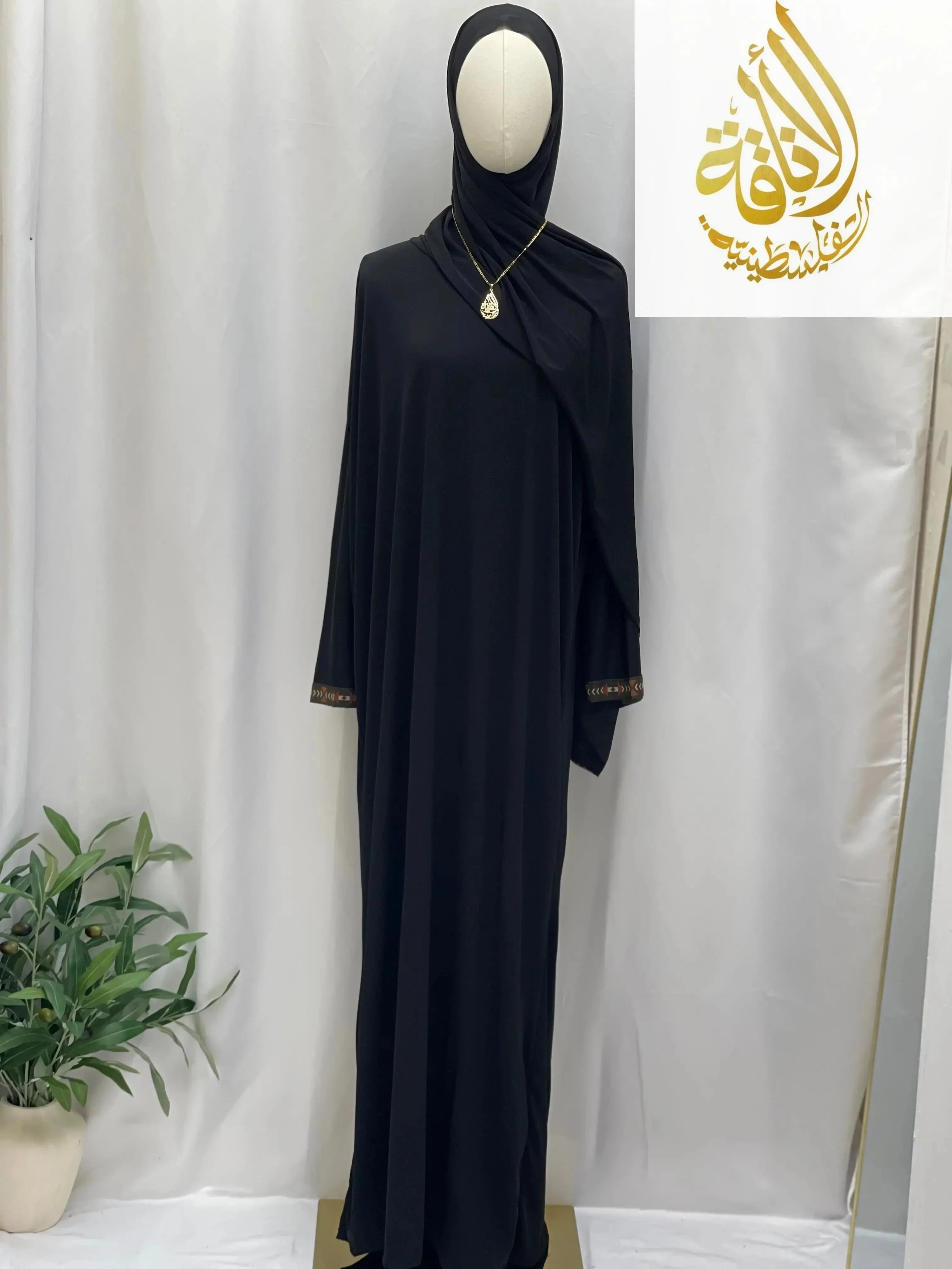 Black abaya one piece prayer dress by Palestinian Elegance with gold trim on sleeves and matching headscarf