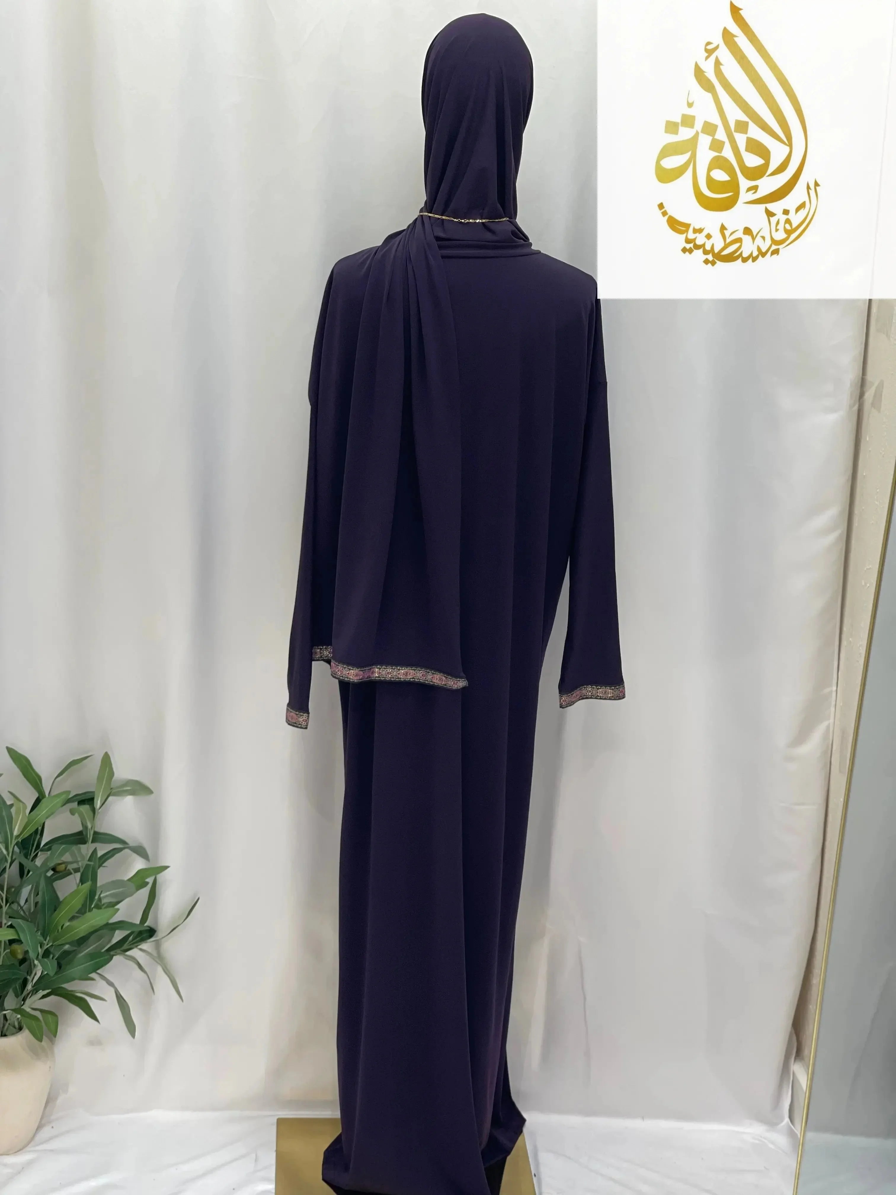 Palestinian Elegance one piece prayer dress abaya in dark purple with gold trim displayed on mannequin back view