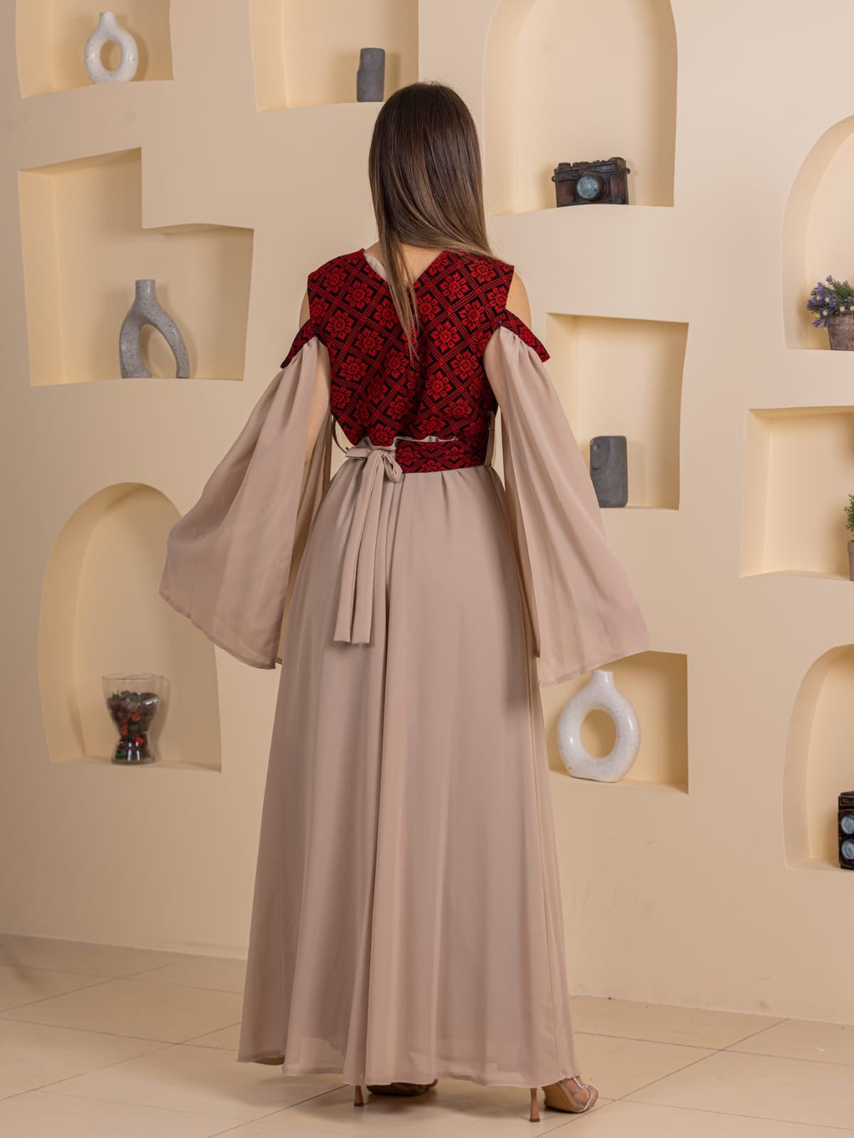 Back view of Palestinian Essence Dress by Palestinian Elegance long beige gown with red embroidered bodice and flowing bell sleeves