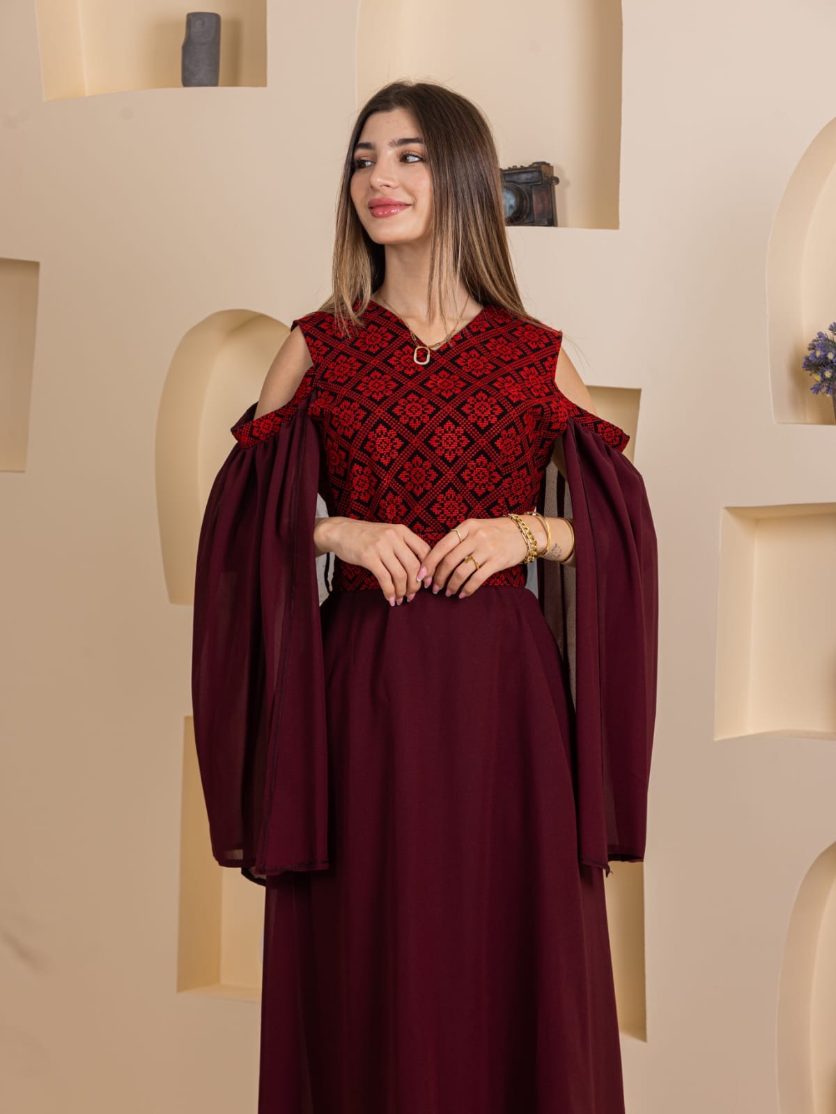 Model wearing Palestinian Essence Dress by Palestinian Elegance burgundy embroidered cold shoulder long gown