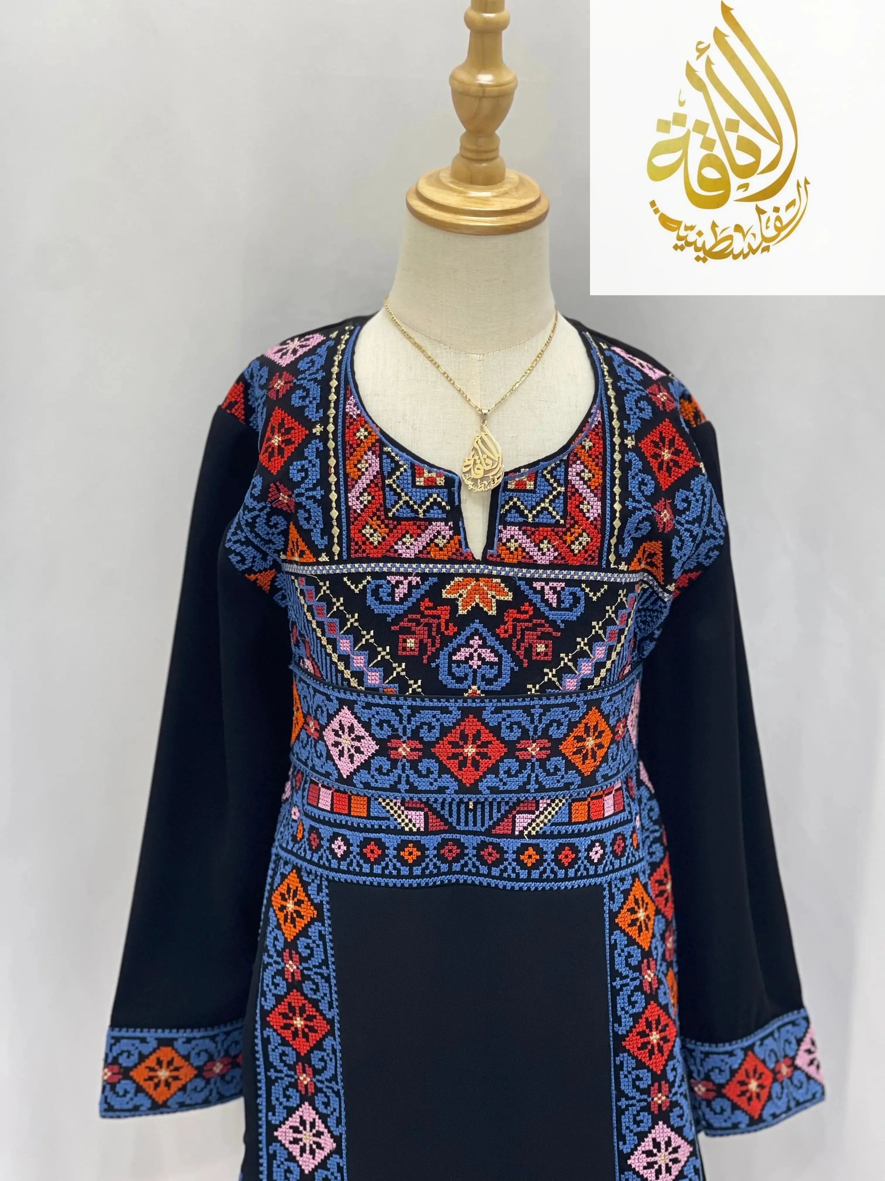 Embroidered thoub for girls by Palestinian Elegance with colorful traditional geometric patterns on black fabric