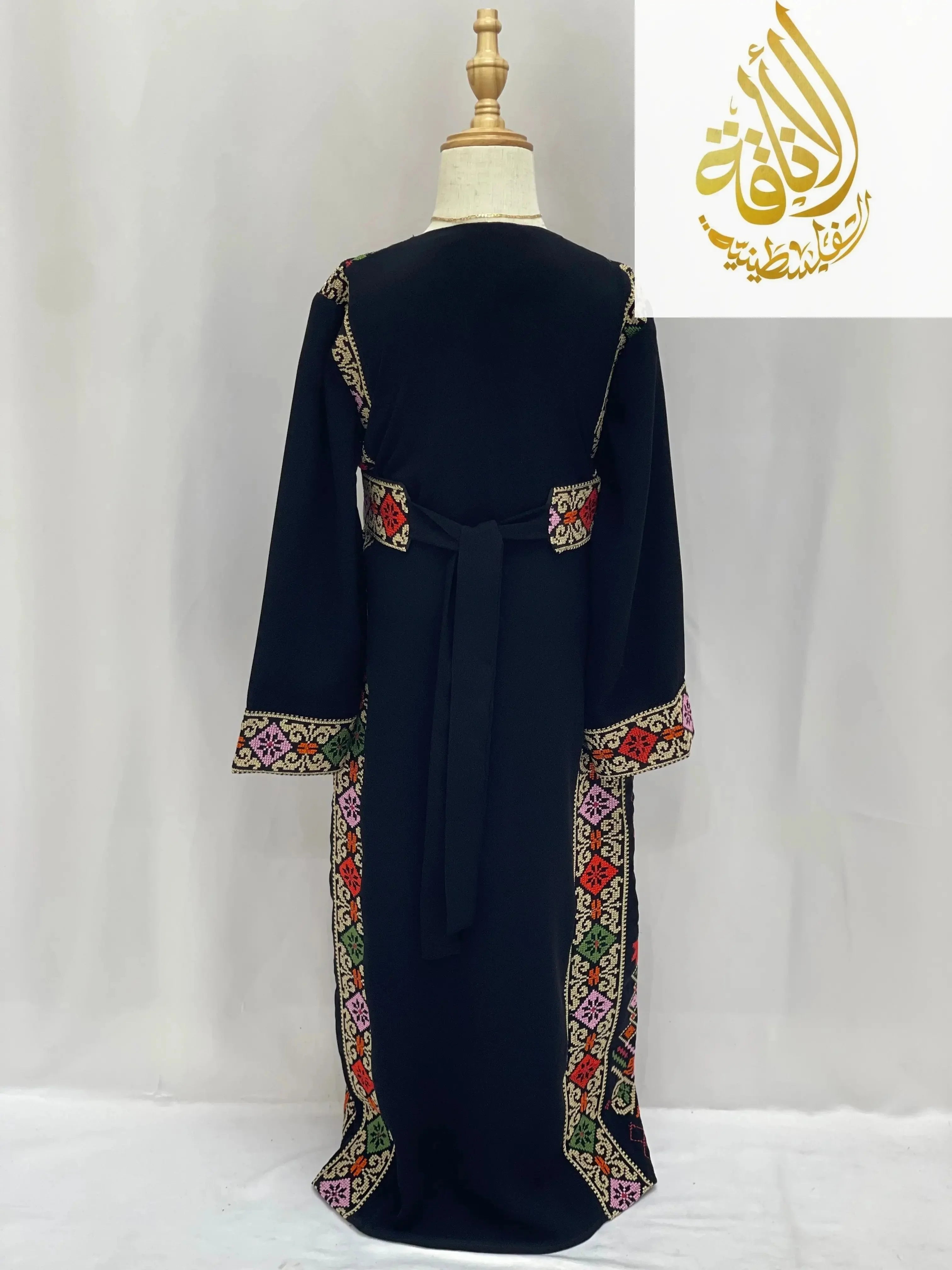 Back view of embroidered thoub for girls with colorful traditional patterns on black fabric by Palestinian Elegance