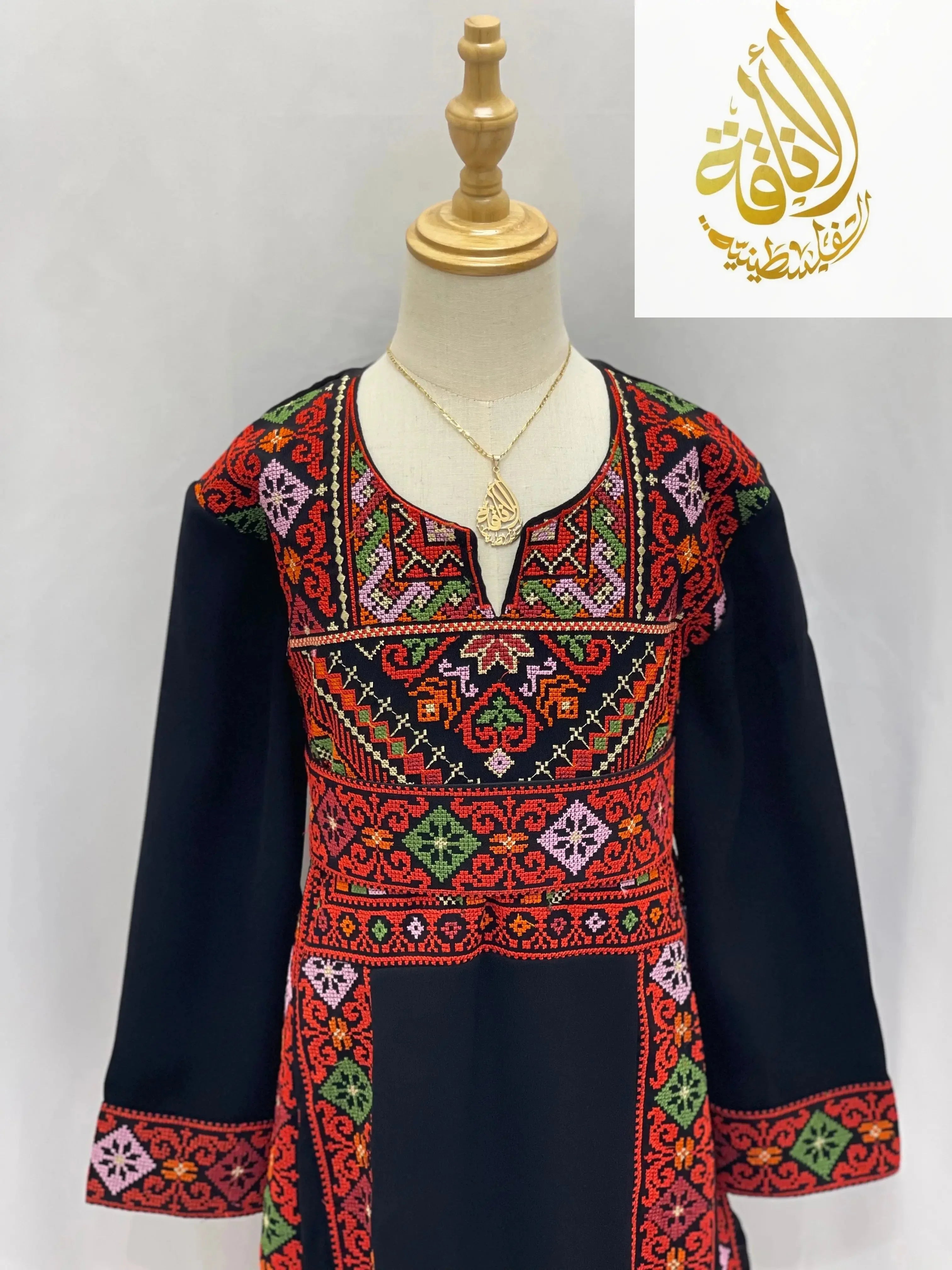 Palestinian Elegance embroidered thoub for girls with traditional red and green embroidery on black fabric