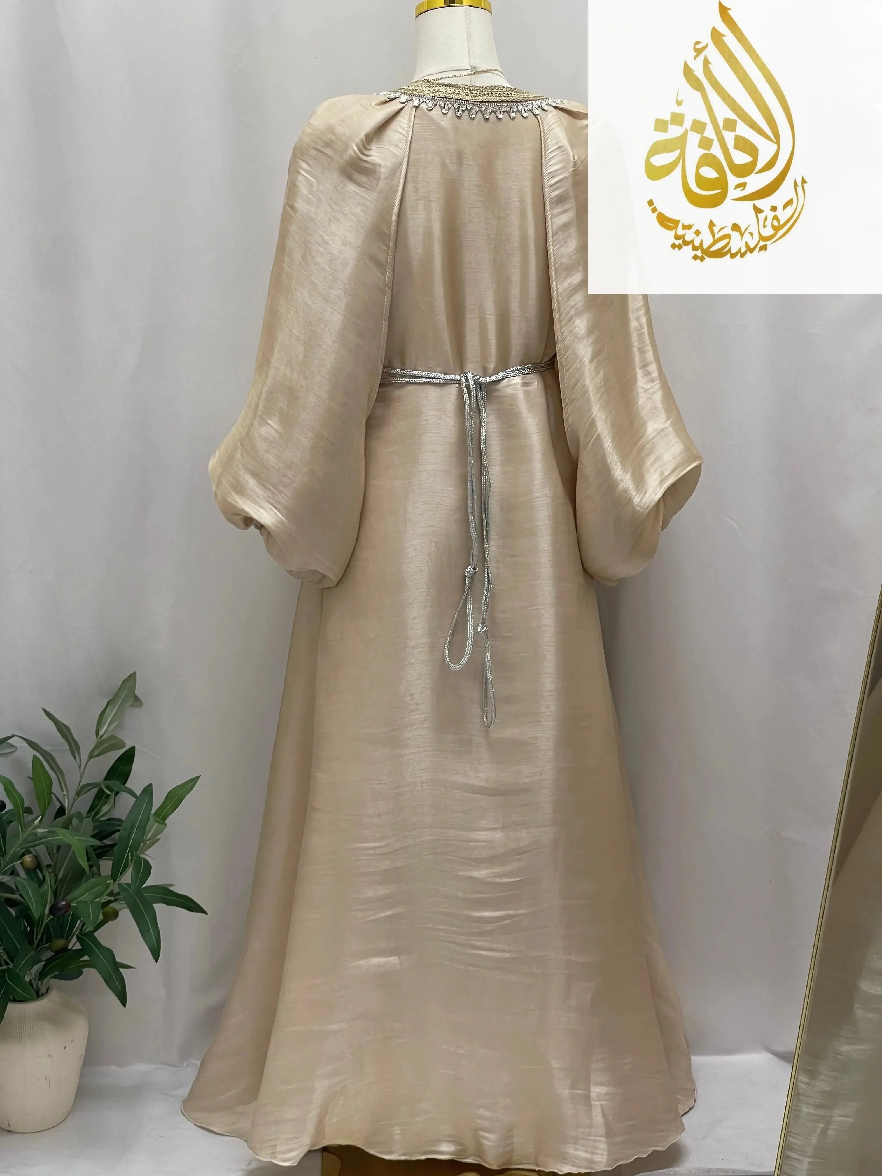 Palestinian Elegance beige puffy sleeves kaftan dress with silver waist tie viewed from the back