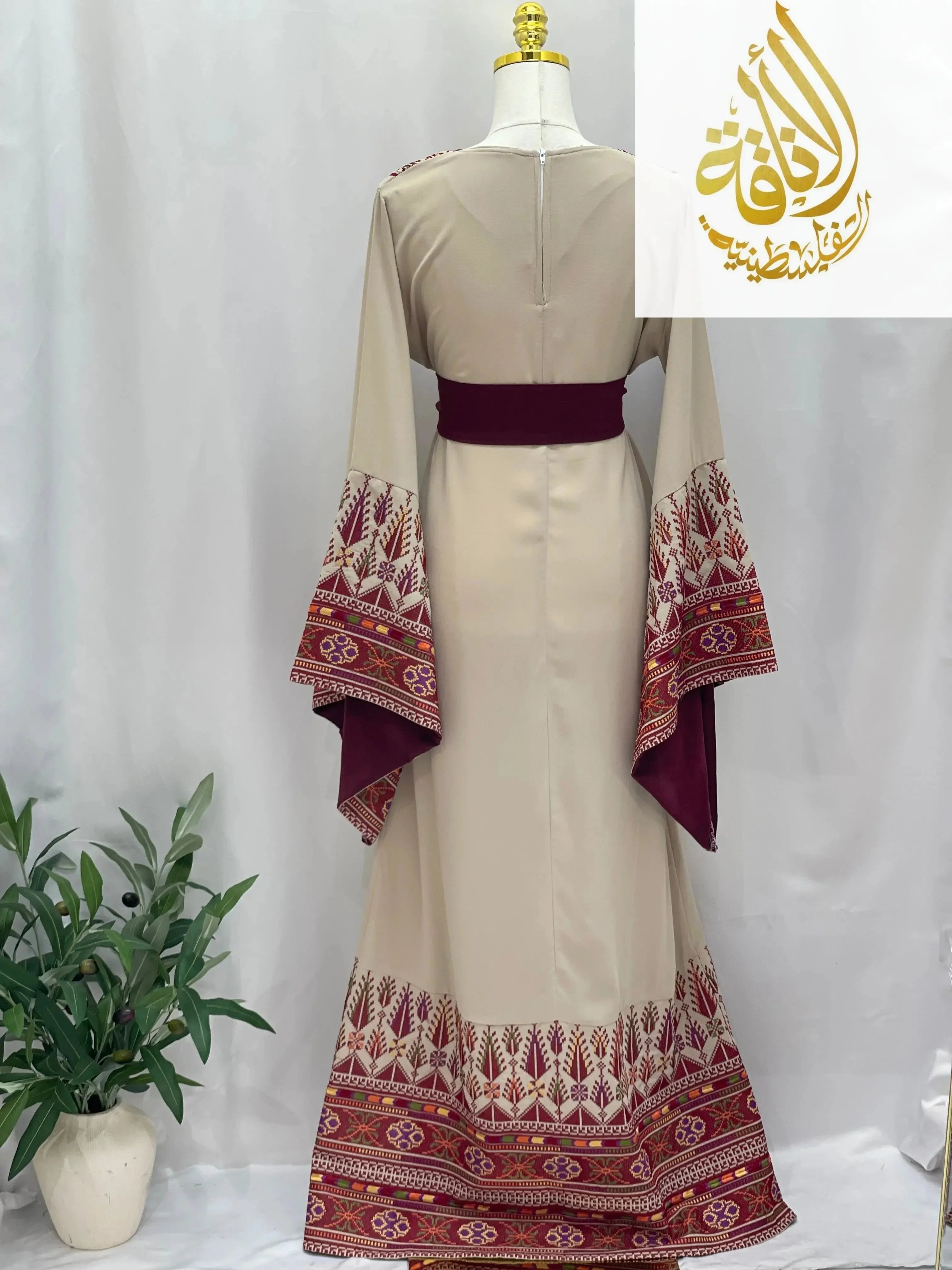 Back view of Randa Embroidered Thoub in beige with maroon and intricate embroidery on sleeves and hem by Palestinian Elegance