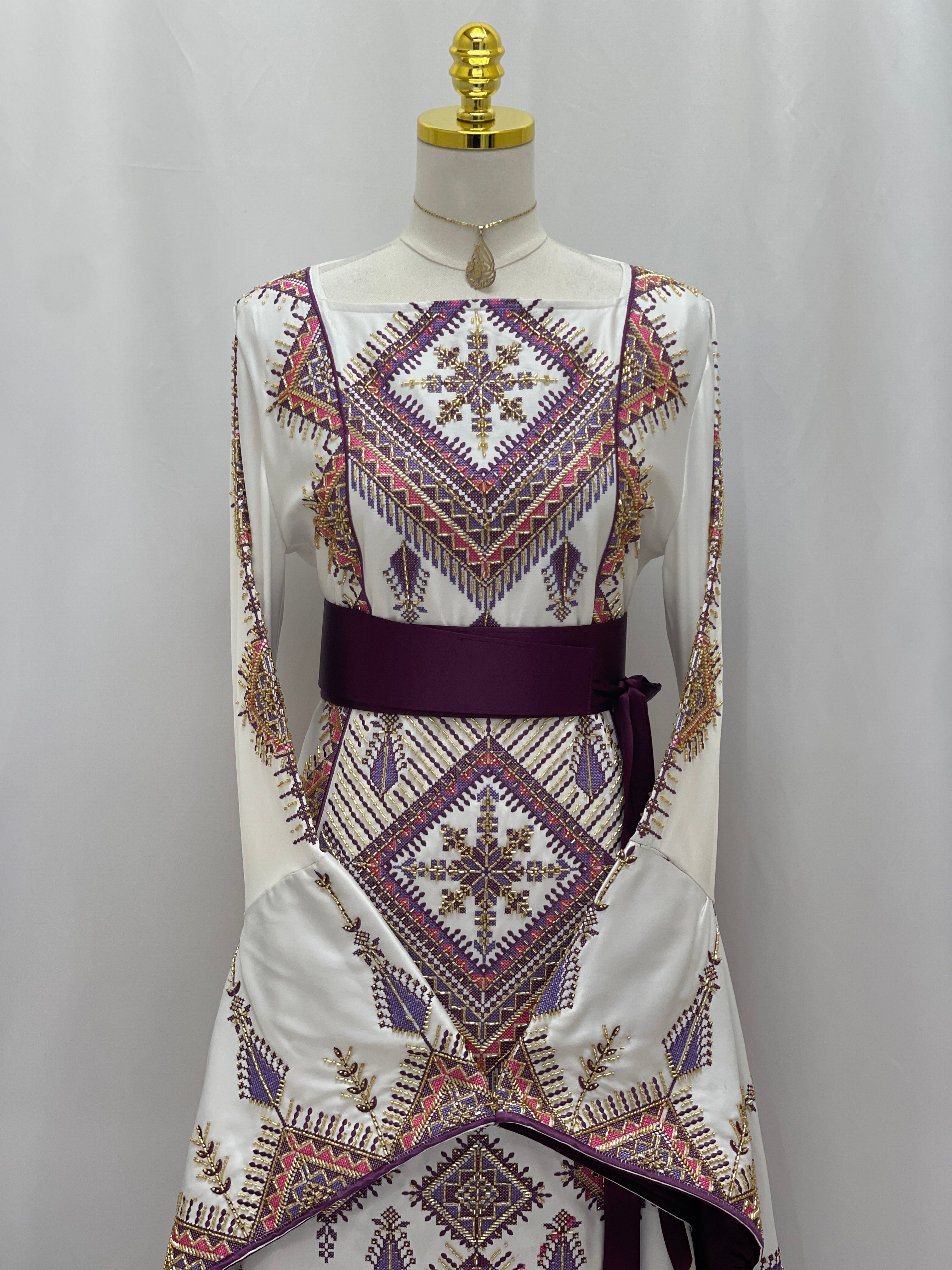 Palestinian Elegance bridal Embroidered Thoub Gown white silk style with purple and gold geometric embroidery and burgundy sash